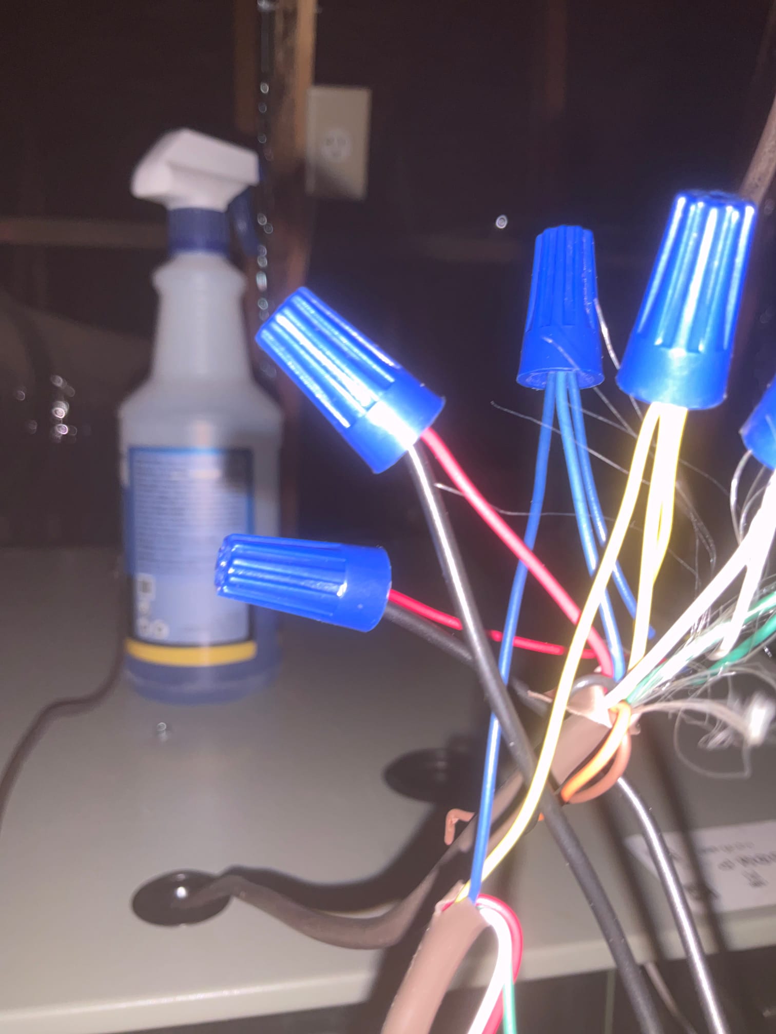 Low-voltage control wires joined with blue wire nuts inside the air handler cabinet during electrical hookup.