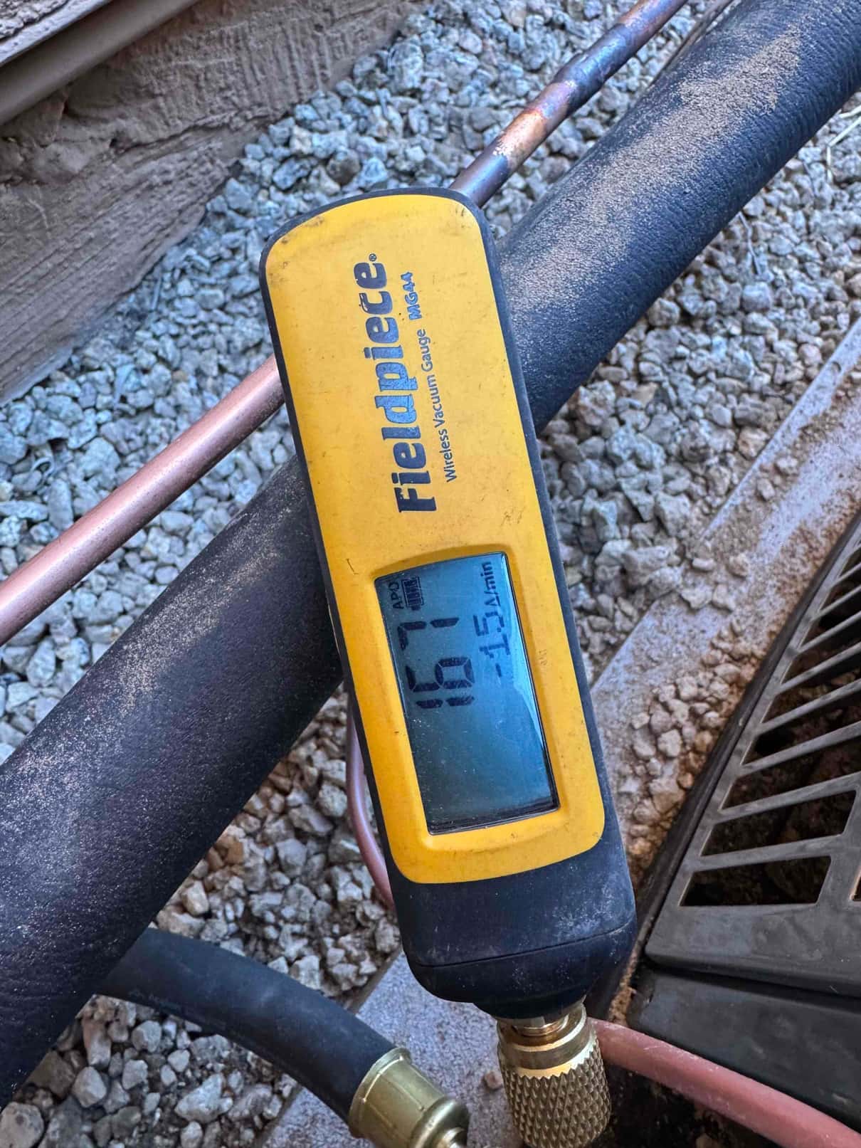 Micron gauge connected to the refrigerant line shows 167 microns, documenting a deep vacuum during system evacuation.