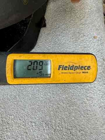 Micron gauge displays 209 microns, documenting a deep vacuum during system evacuation before charging.