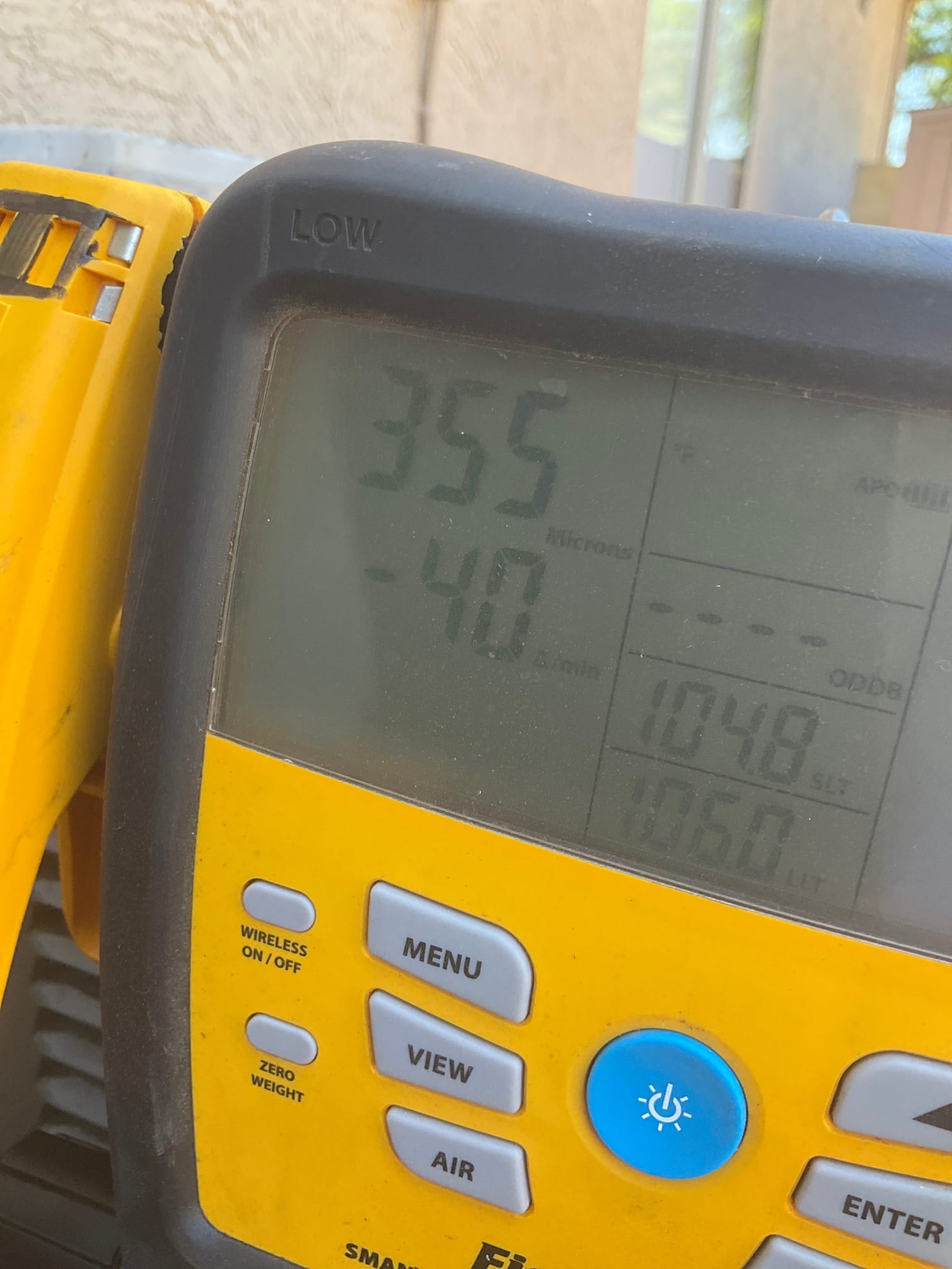Micron gauge displays 355 microns, confirming a deep vacuum on the new refrigerant circuit before charging.
