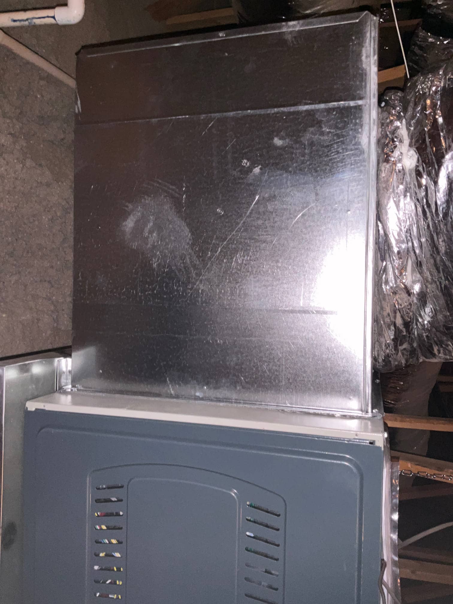 New furnace and sheet-metal supply plenum installed in the attic, with duct connections and sealed transitions visible.