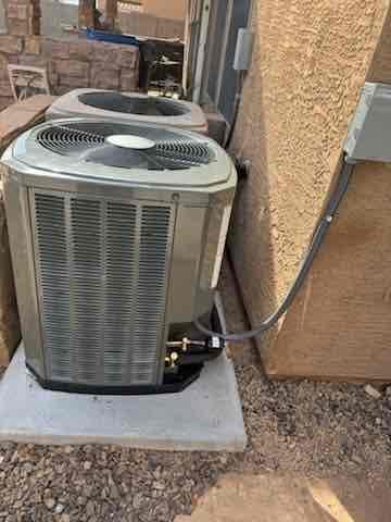 New outdoor condenser set on a level pad with electrical disconnect mounted and liquid and suction lines connected and insulated.