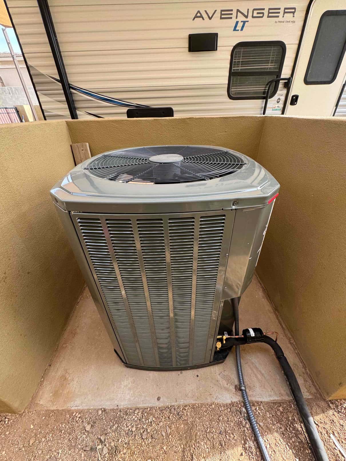 New outdoor heat pump condenser set on a level pad with insulated line set, filter-drier, and electrical whip connected.