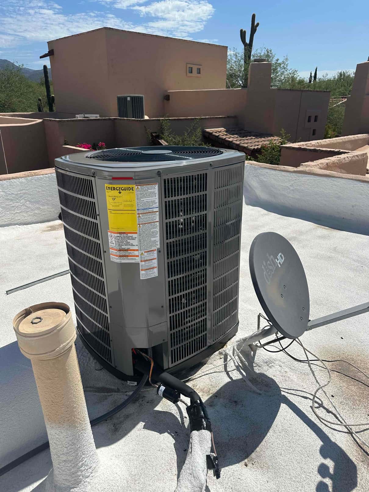 New rooftop condenser set on the roof with insulated refrigerant lines and electrical whip routed to the unit.