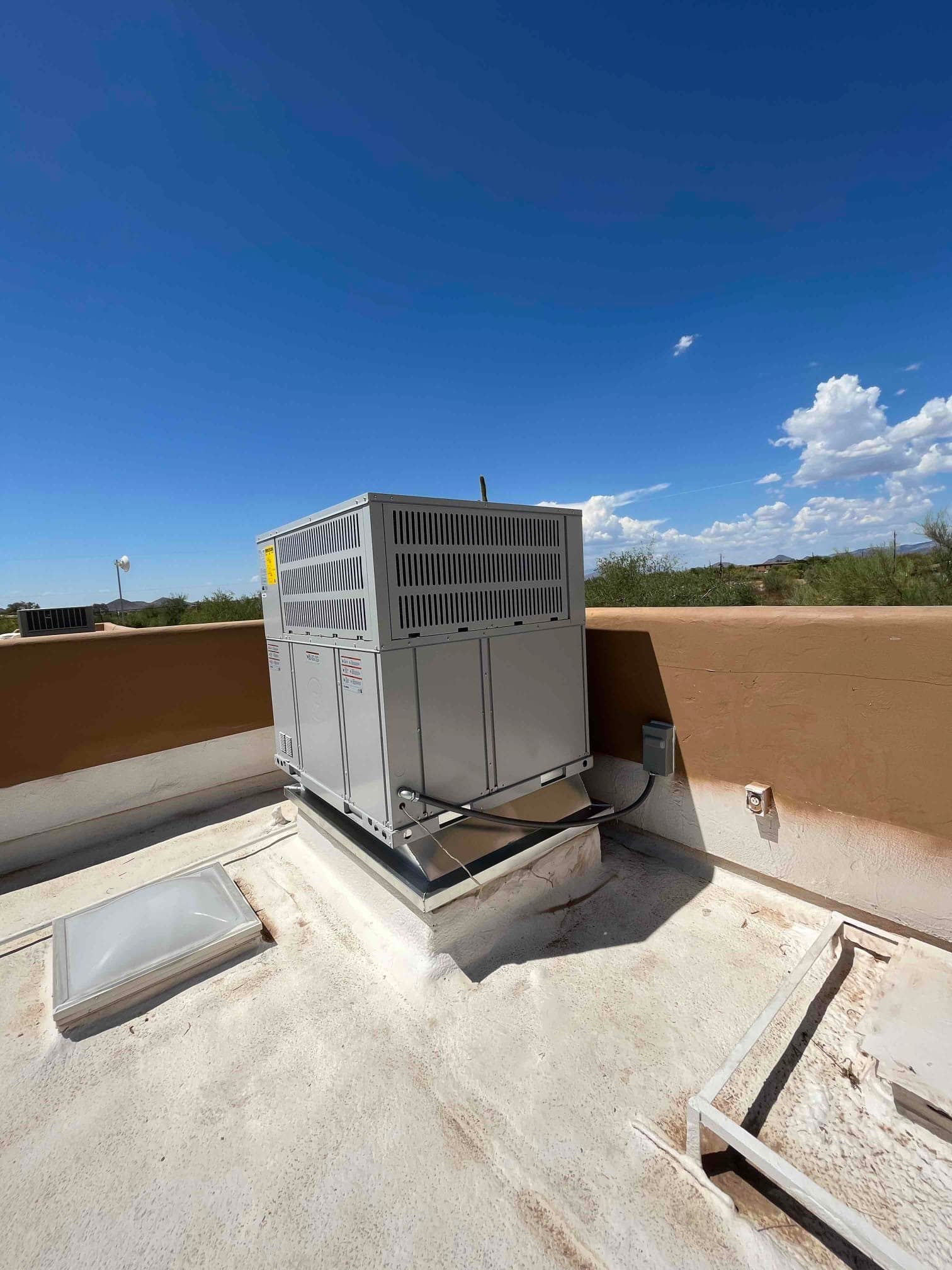 New rooftop packaged HVAC unit set on a curb with electrical whip connected and rooftop penetration sealed.
