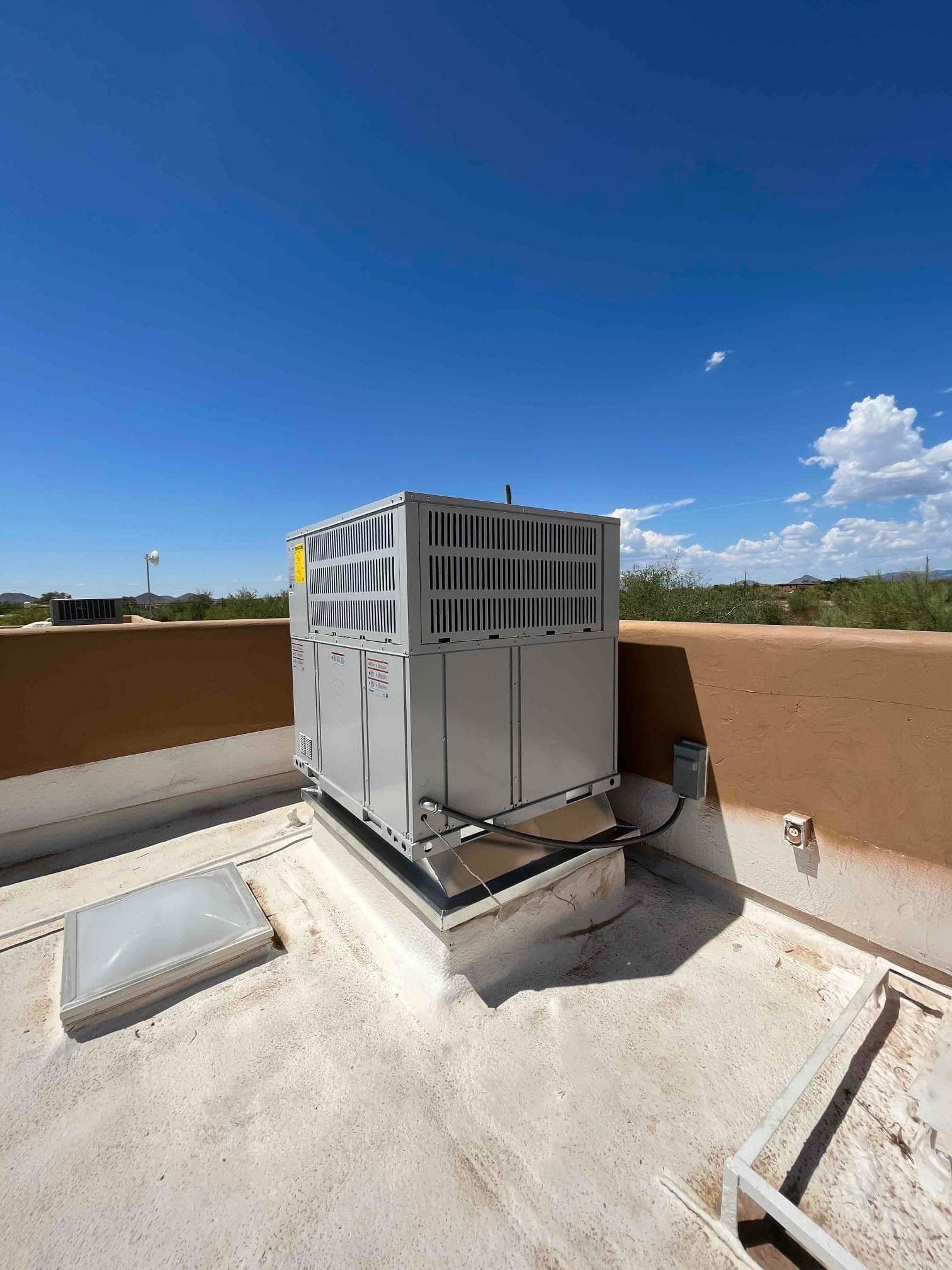 New rooftop packaged HVAC unit set on a curb with sealed roof penetration and connected electrical disconnect.