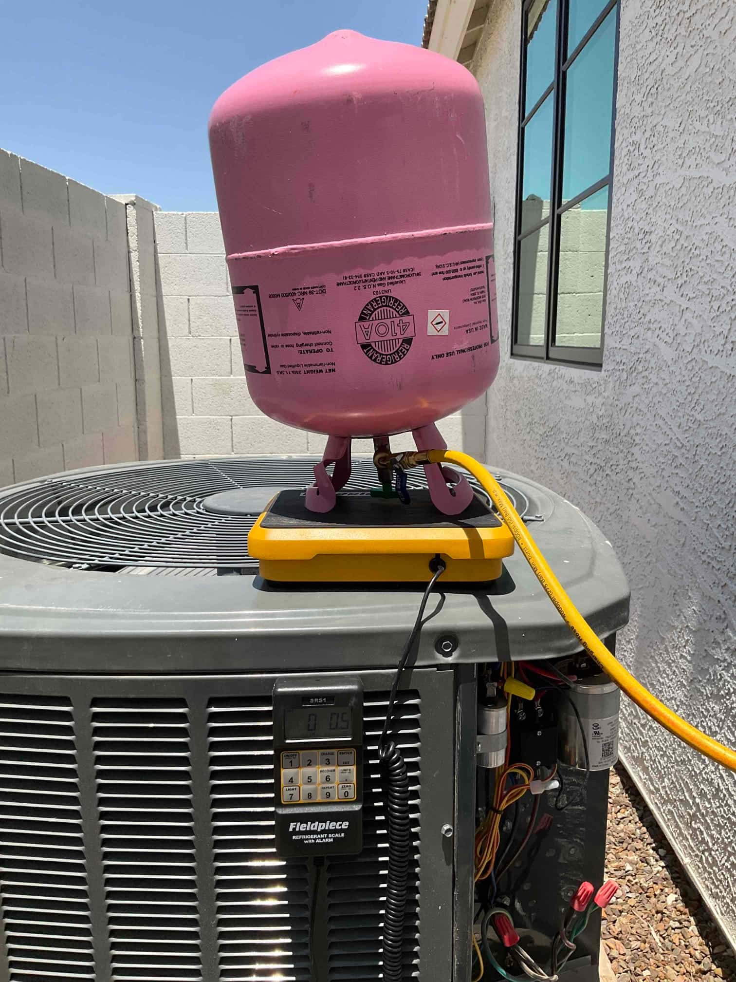 Refrigerant scale photographed during the service visit; no numerical reading is transcribed.