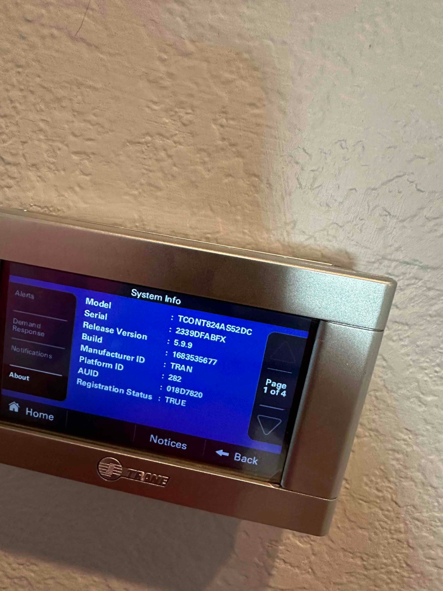 Wall-mounted thermostat displays system information on its screen after installation, showing menu navigation and status options.