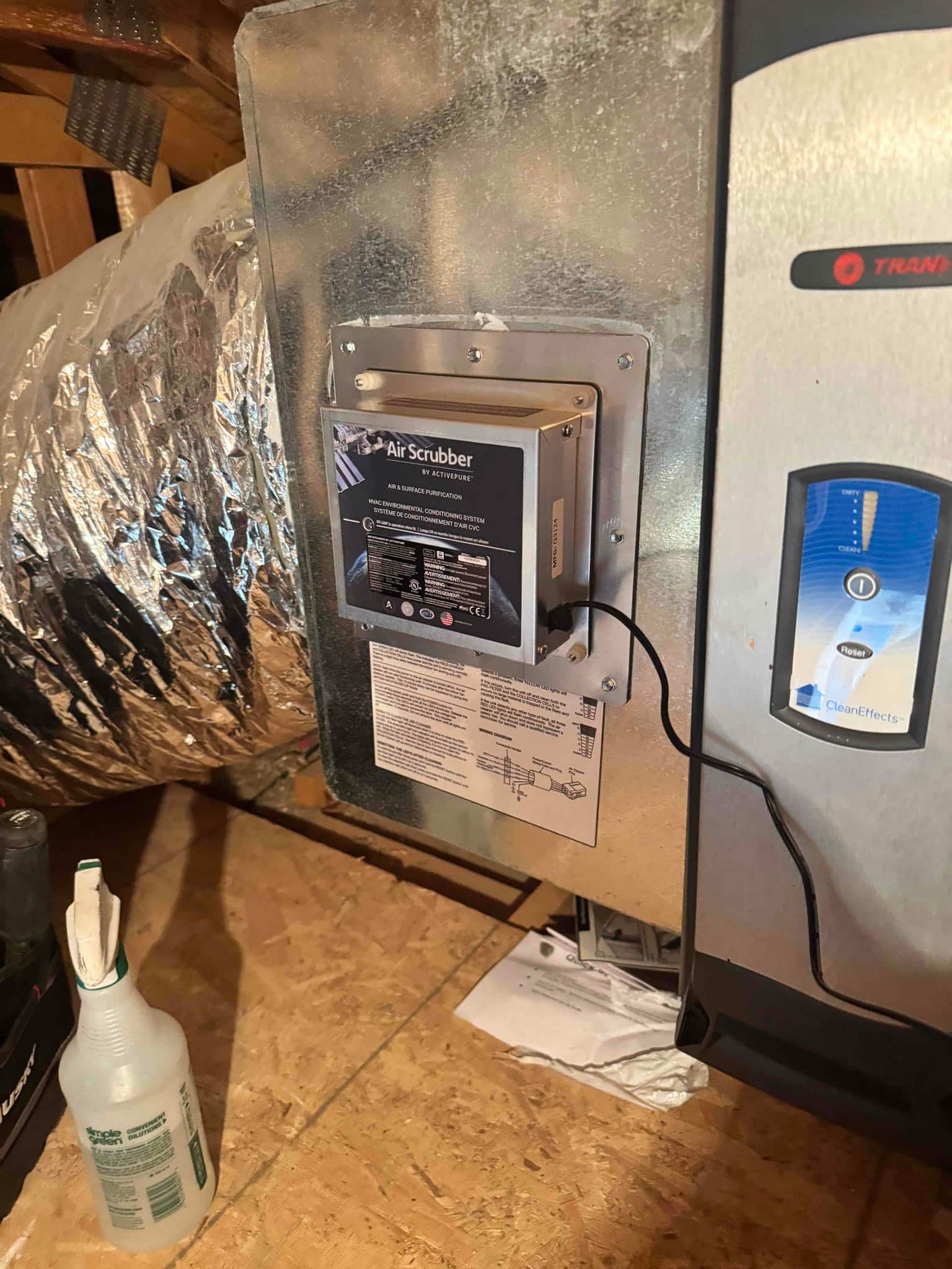 Whole-home air scrubber installed on supply duct near the air handler, with wiring connected and installation instructions attached below.