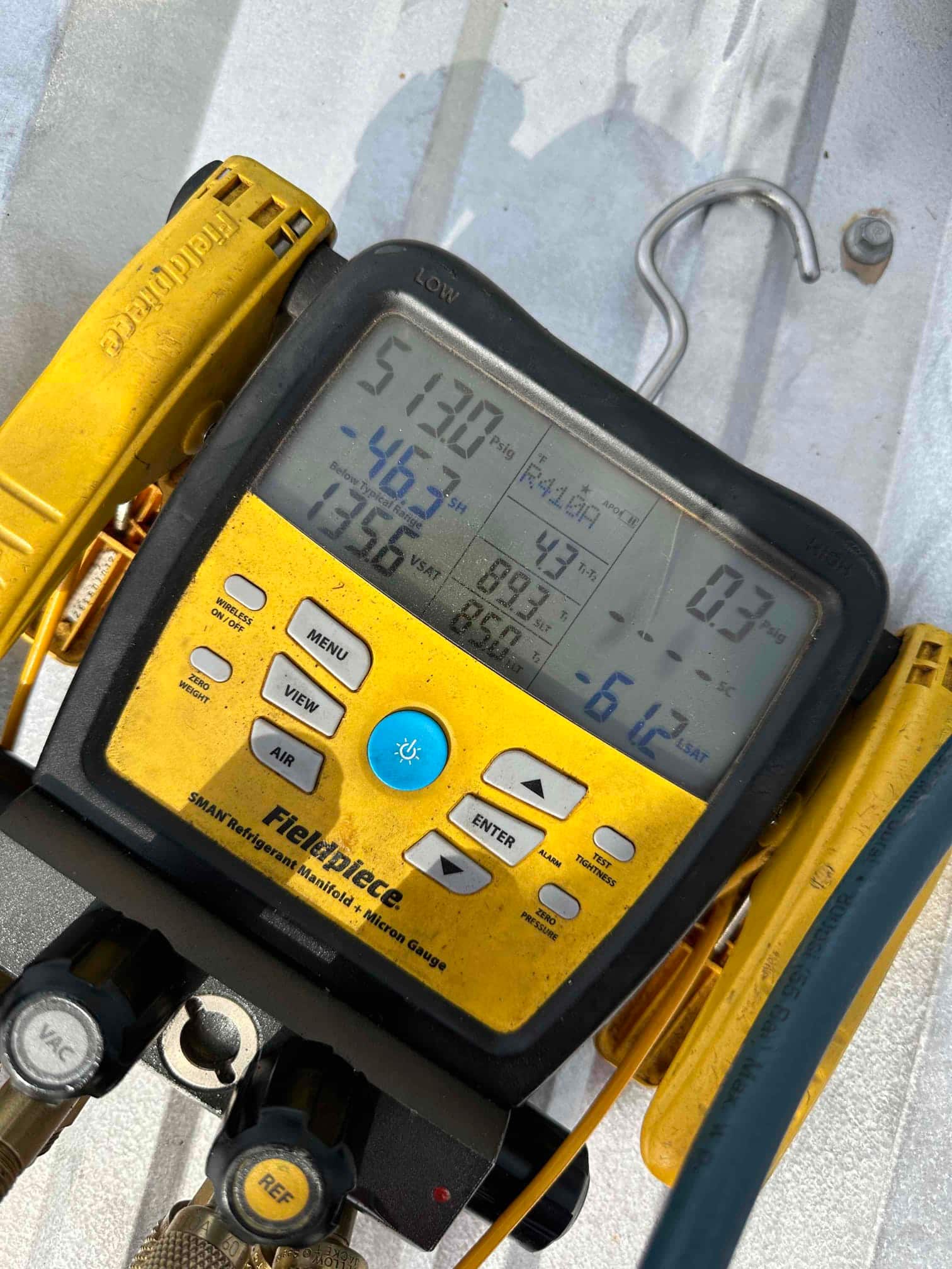 Digital manifold shows system operating with split pressures and computed superheat and subcooling during mini‑split commissioning.