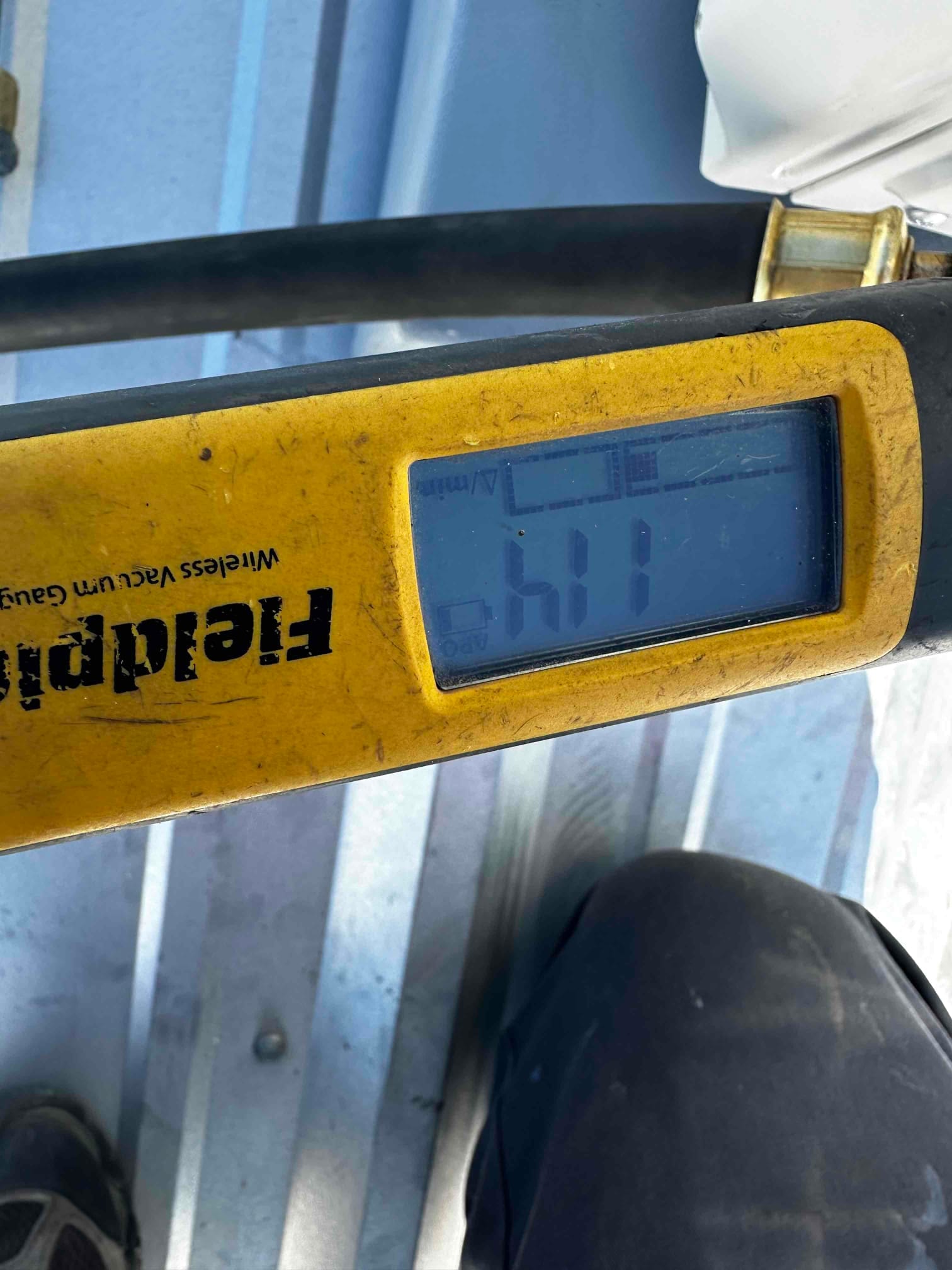 Digital micron gauge connected during evacuation shows a deep vacuum below 500 microns prior to refrigerant charging.