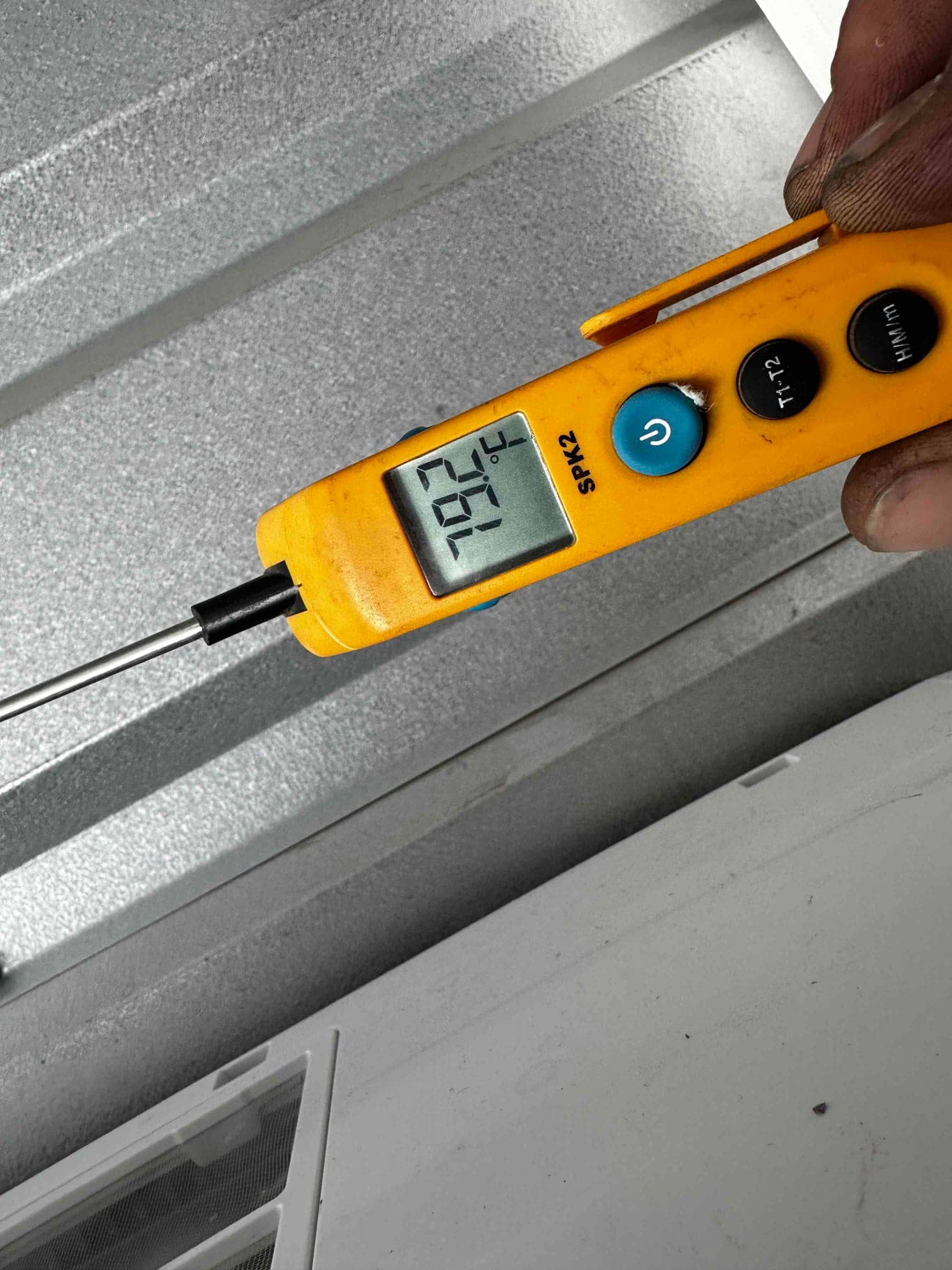 Digital thermometer probe shows 79.2°F while measuring air temperature at the indoor unit grille.
