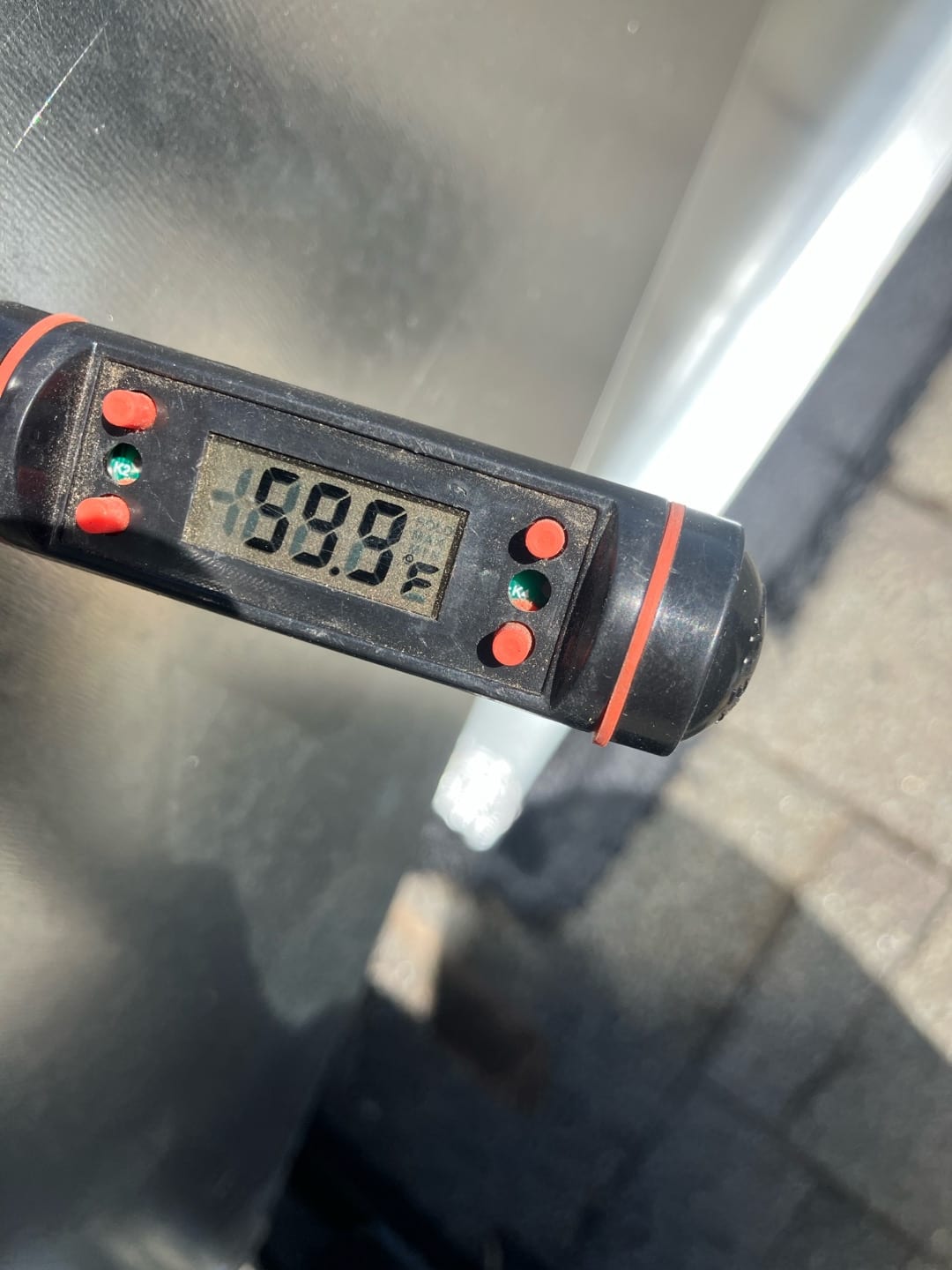 Digital thermometer displays 69.9 degrees Fahrenheit while checking air temperature during HVAC system commissioning.