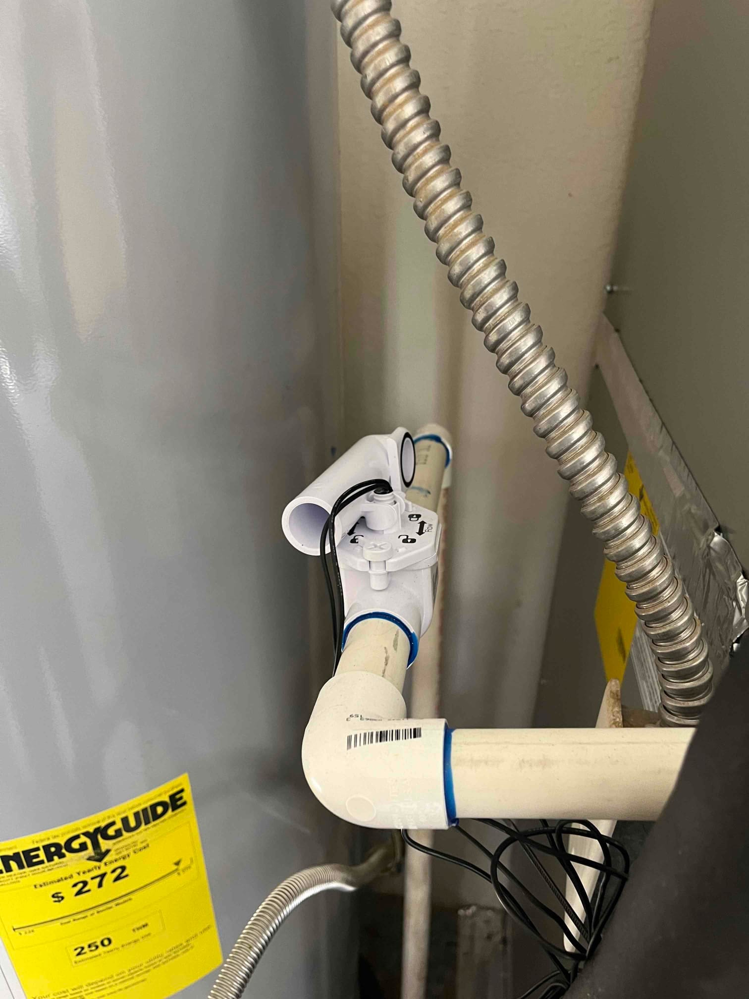 Condensate drain assembly with cleanout tee and float safety switch installed on PVC piping near the indoor unit.