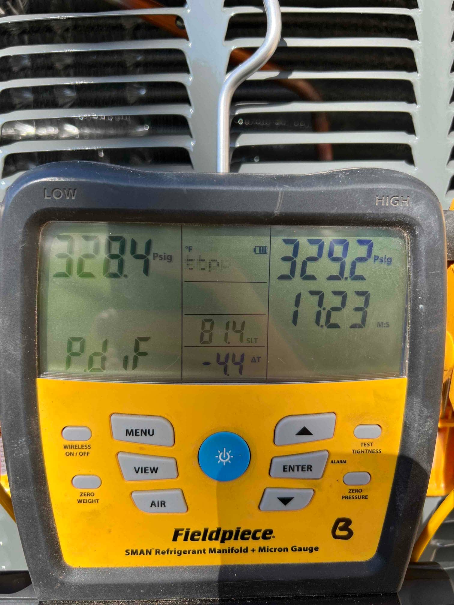 Digital manifold shows equal pressures around 329 PSI on both sides during a nitrogen pressure test at the outdoor unit.