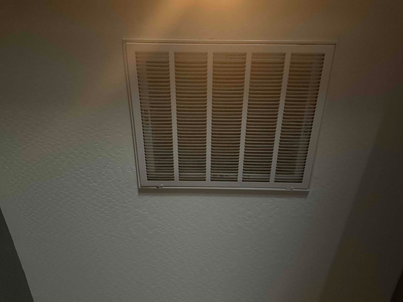 Ceiling return air grille installed cleanly with even louvers and secure mounting tabs visible along the bottom edge.