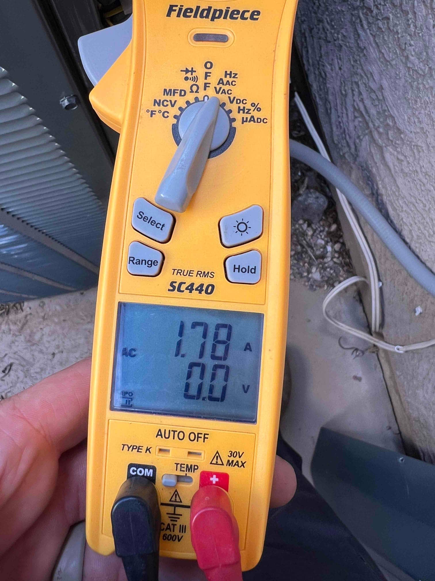 Clamp meter displays 1.78 A AC on the clamped conductor at the outdoor unit, showing live operating current.