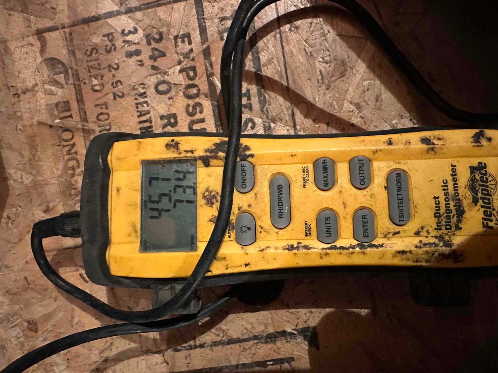 Digital in-duct thermometer displays temperature readings during air-side commissioning on a newly installed HVAC system.