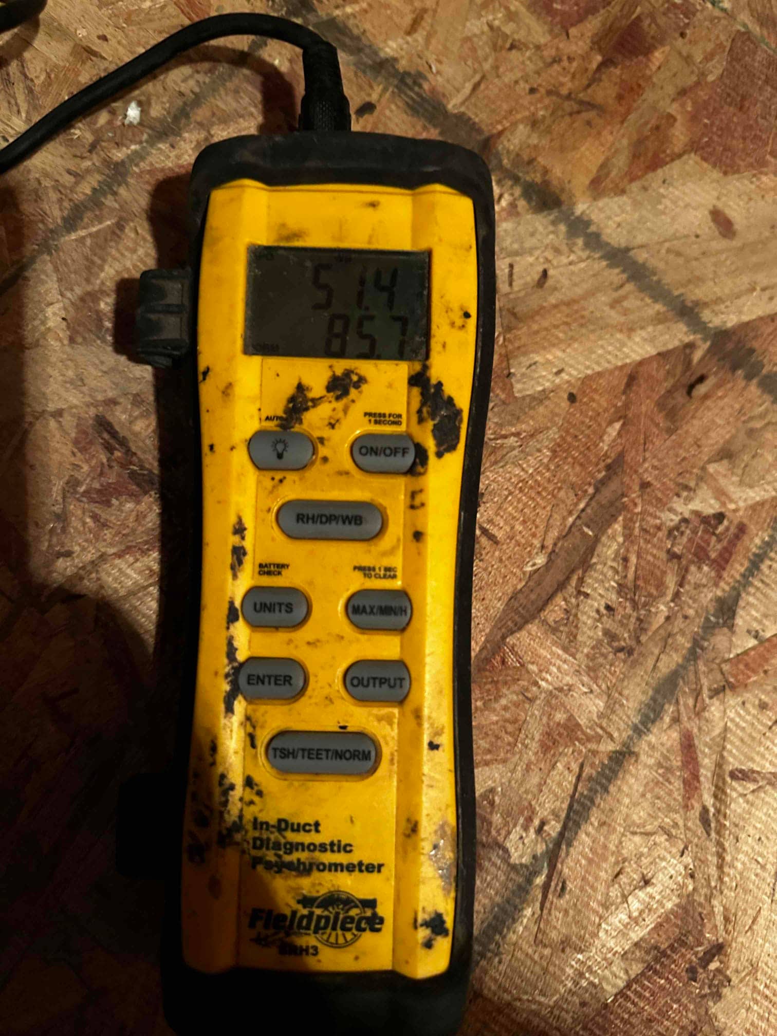 Digital in-duct thermometer shows 51.4°F, documenting supply air temperature during cooling verification.
