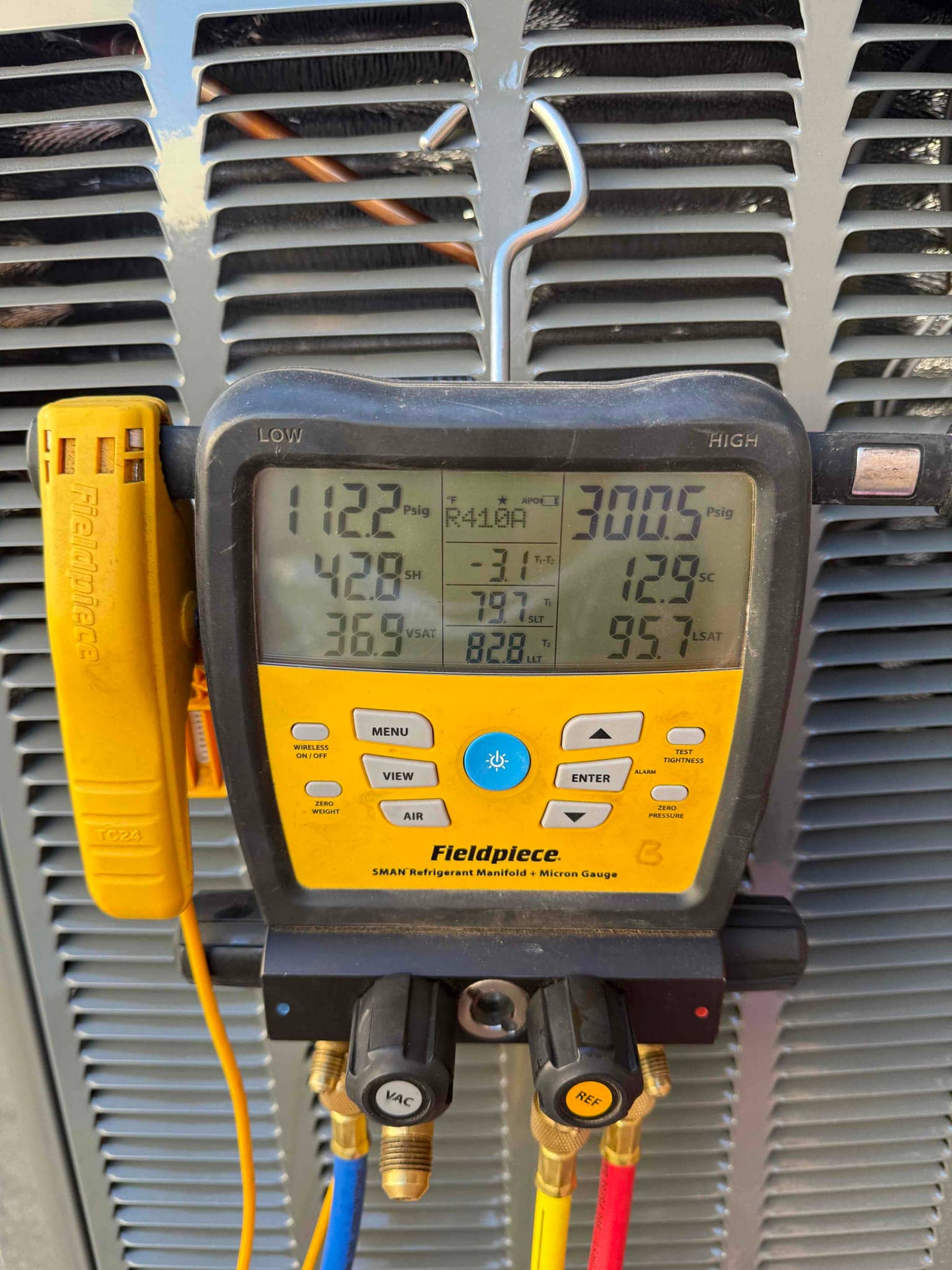 Digital manifold connected to the condenser shows operating pressures and temperatures during system commissioning.