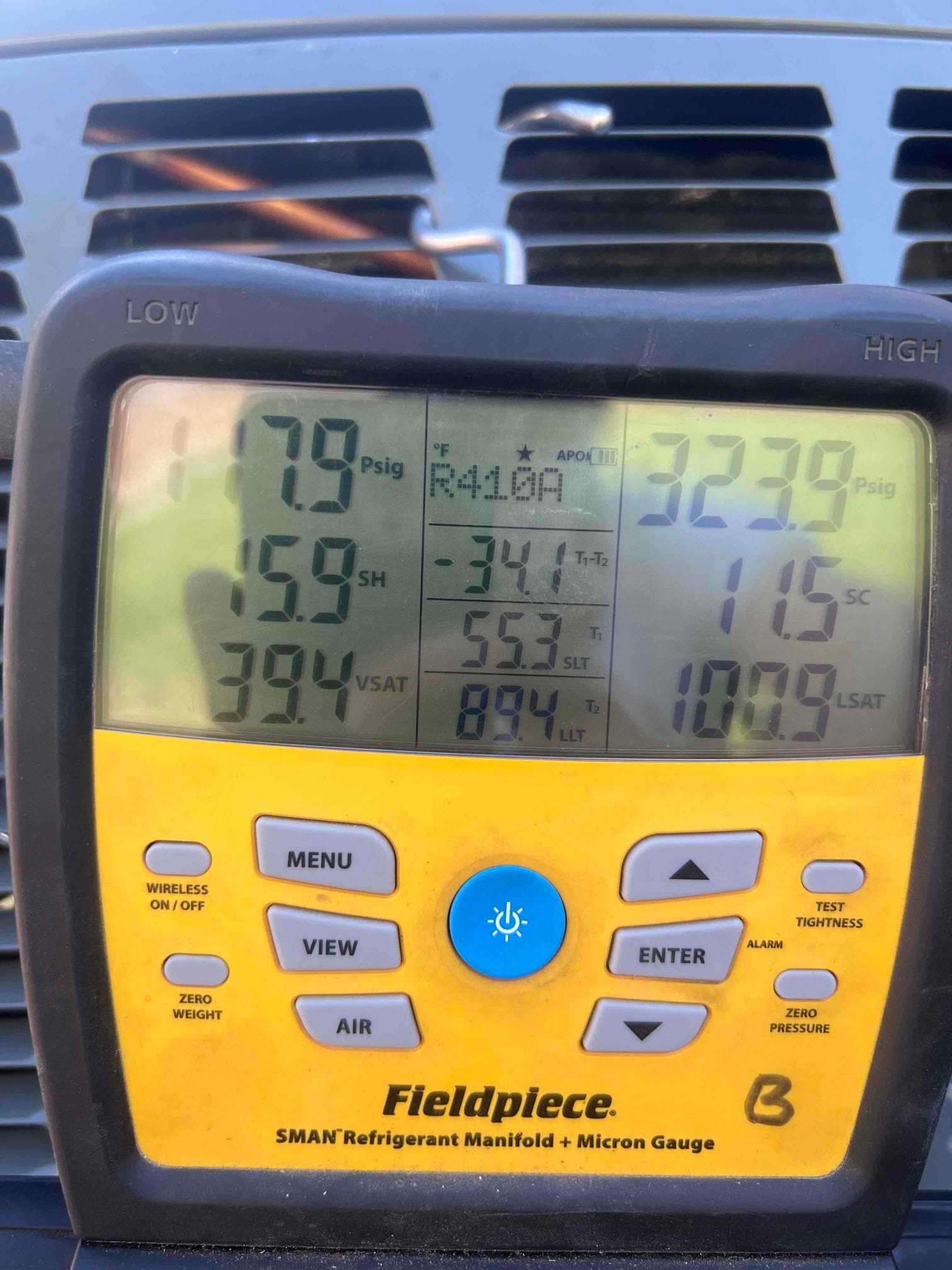 Digital manifold shows operating pressures on a running system during commissioning, with superheat and subcooling values displayed.