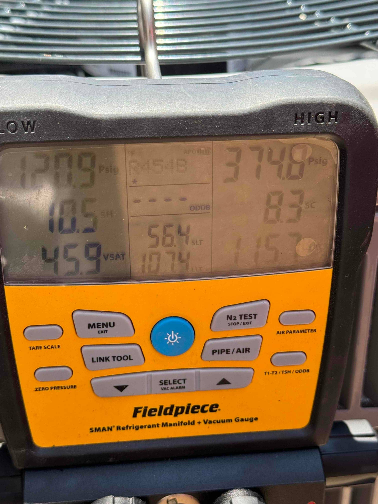 Digital manifold shows system operating pressures with suction at 121 PSI and liquid at 375 PSI during commissioning.