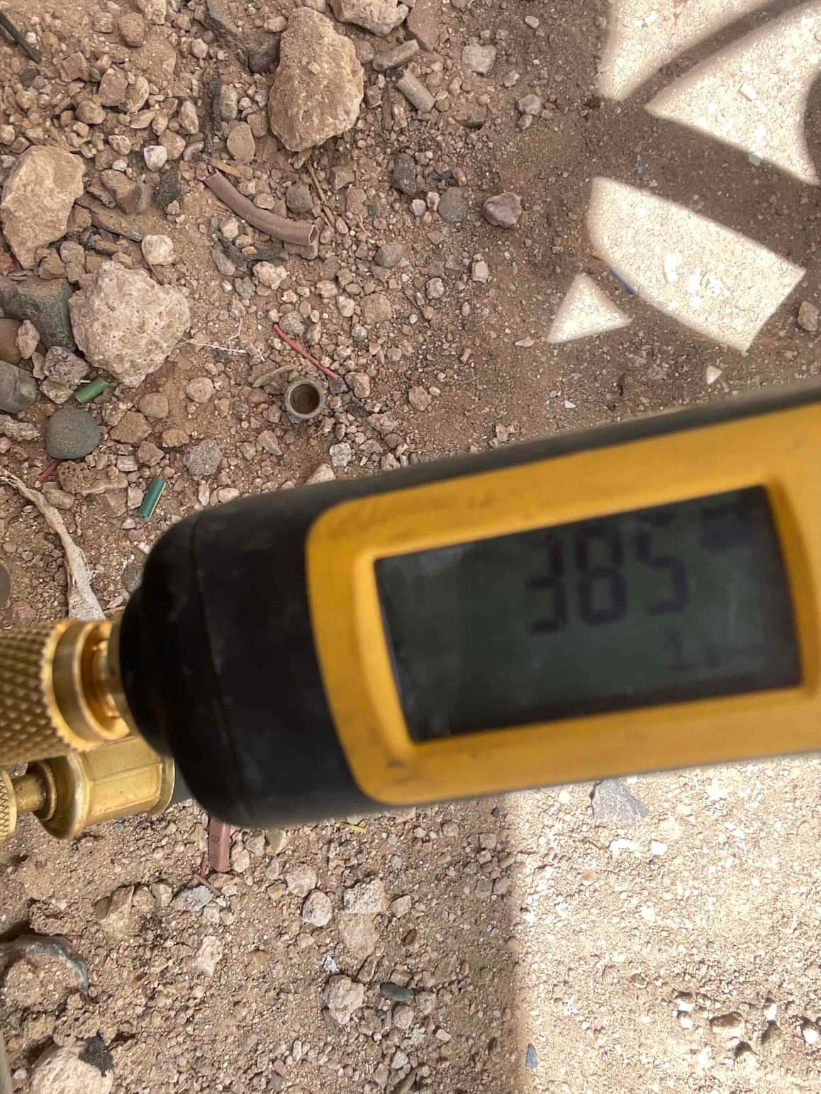 Digital micron gauge connected to the service port displays 385 microns during the evacuation process before refrigerant charging.