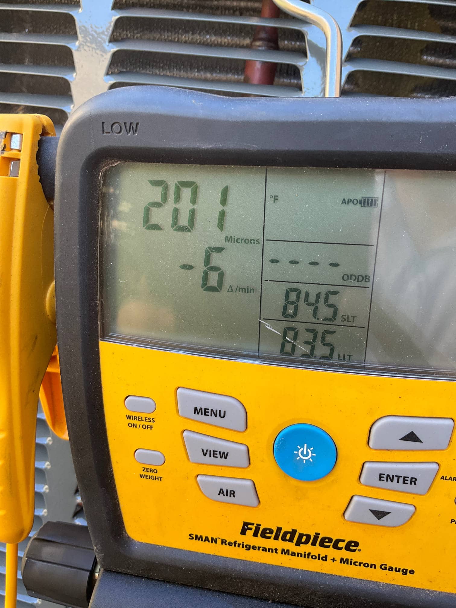 Digital micron gauge on the manifold shows 201 microns with a decreasing rate, confirming a deep evacuation before charging.