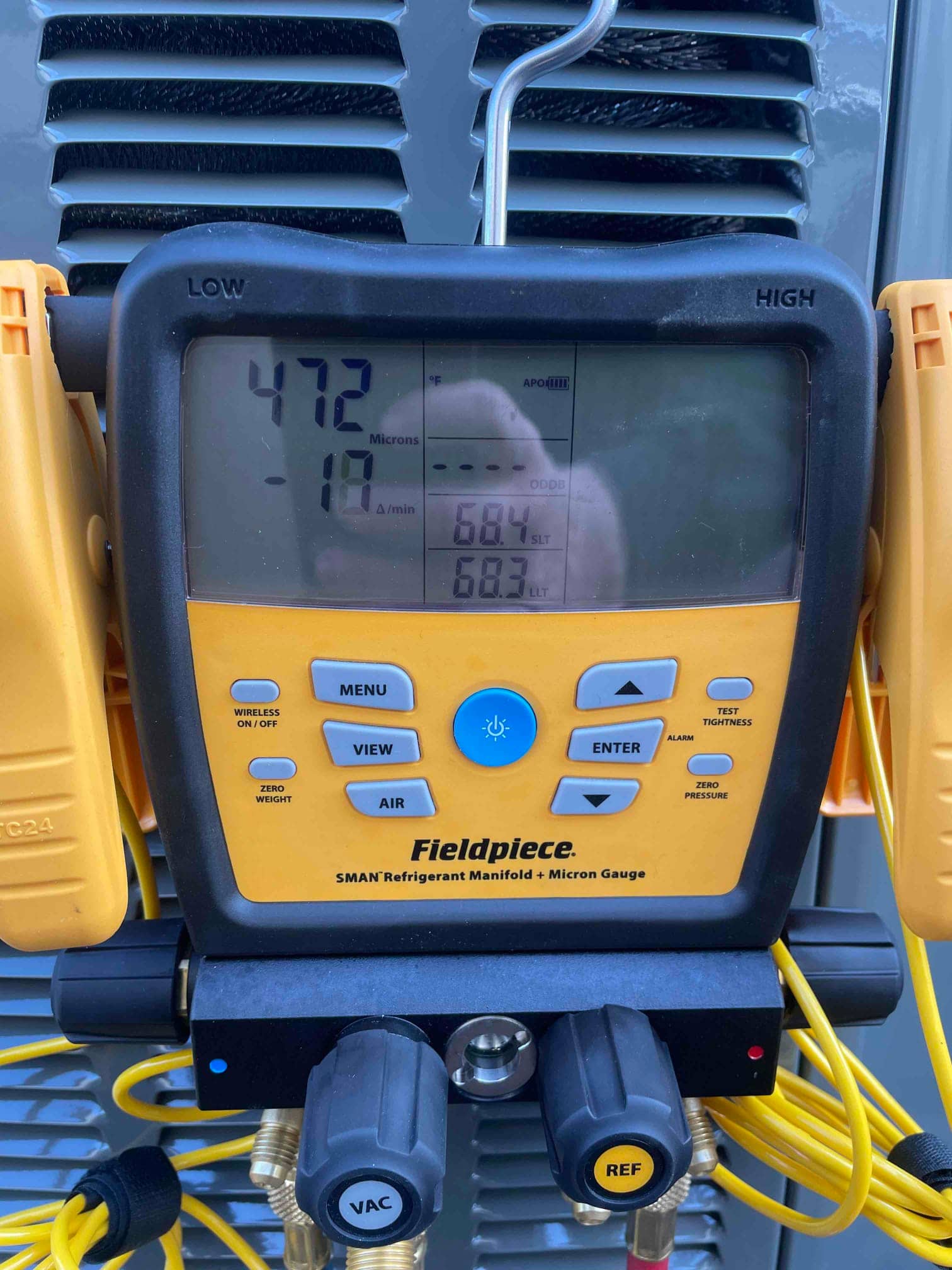 Digital micron gauge on the manifold shows 472 microns during system evacuation prior to refrigerant charging.