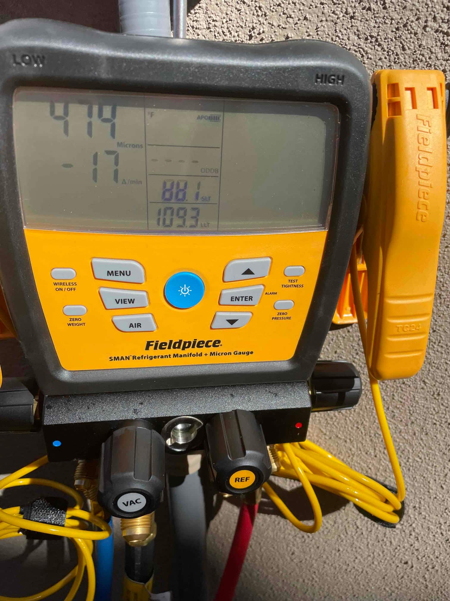 Digital micron gauge on the manifold shows a deep vacuum at 474 microns during system evacuation.