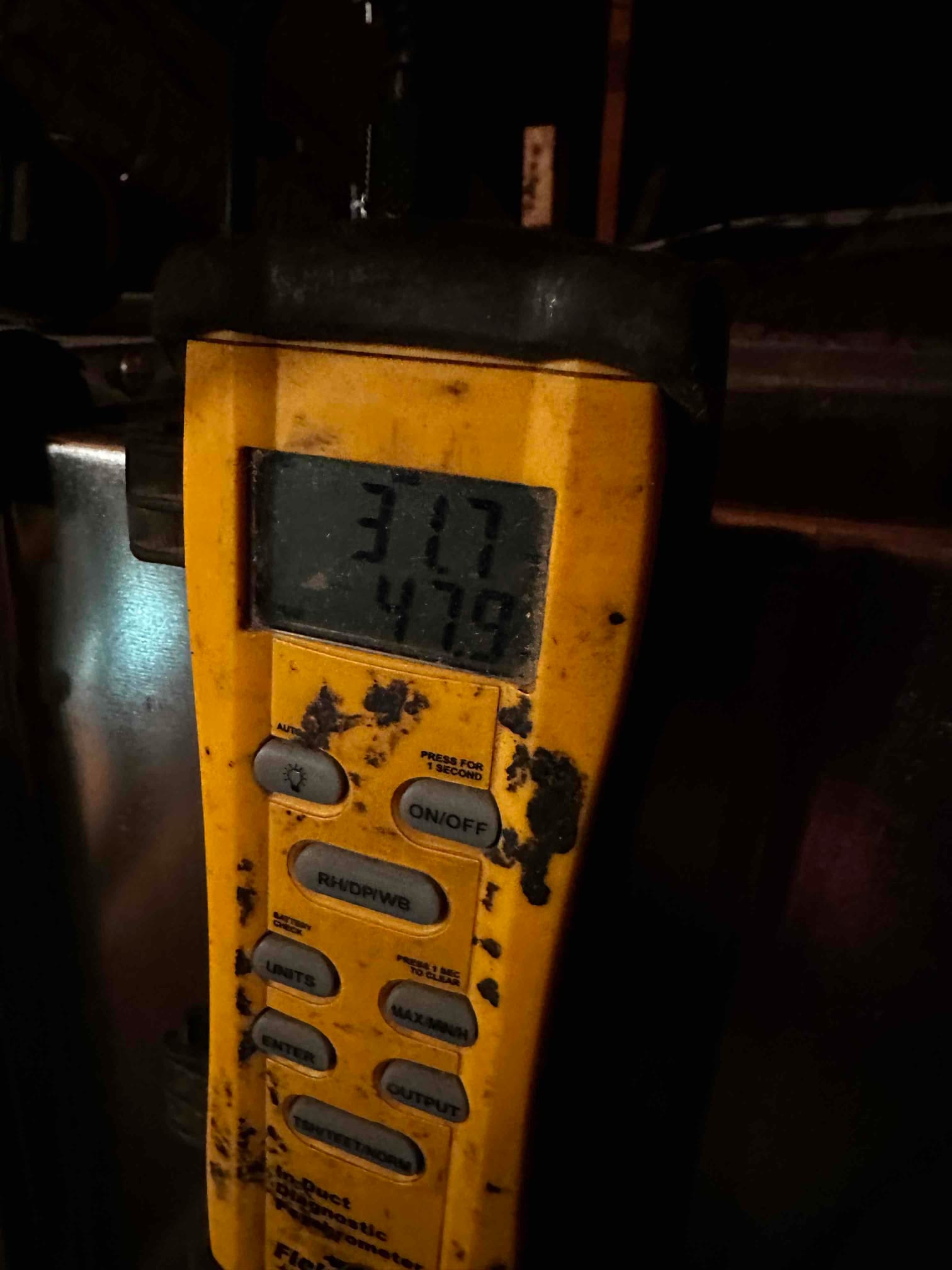 Digital thermometer shows 47.9 degrees on the lower display while measuring supply air temperature at the air handler.