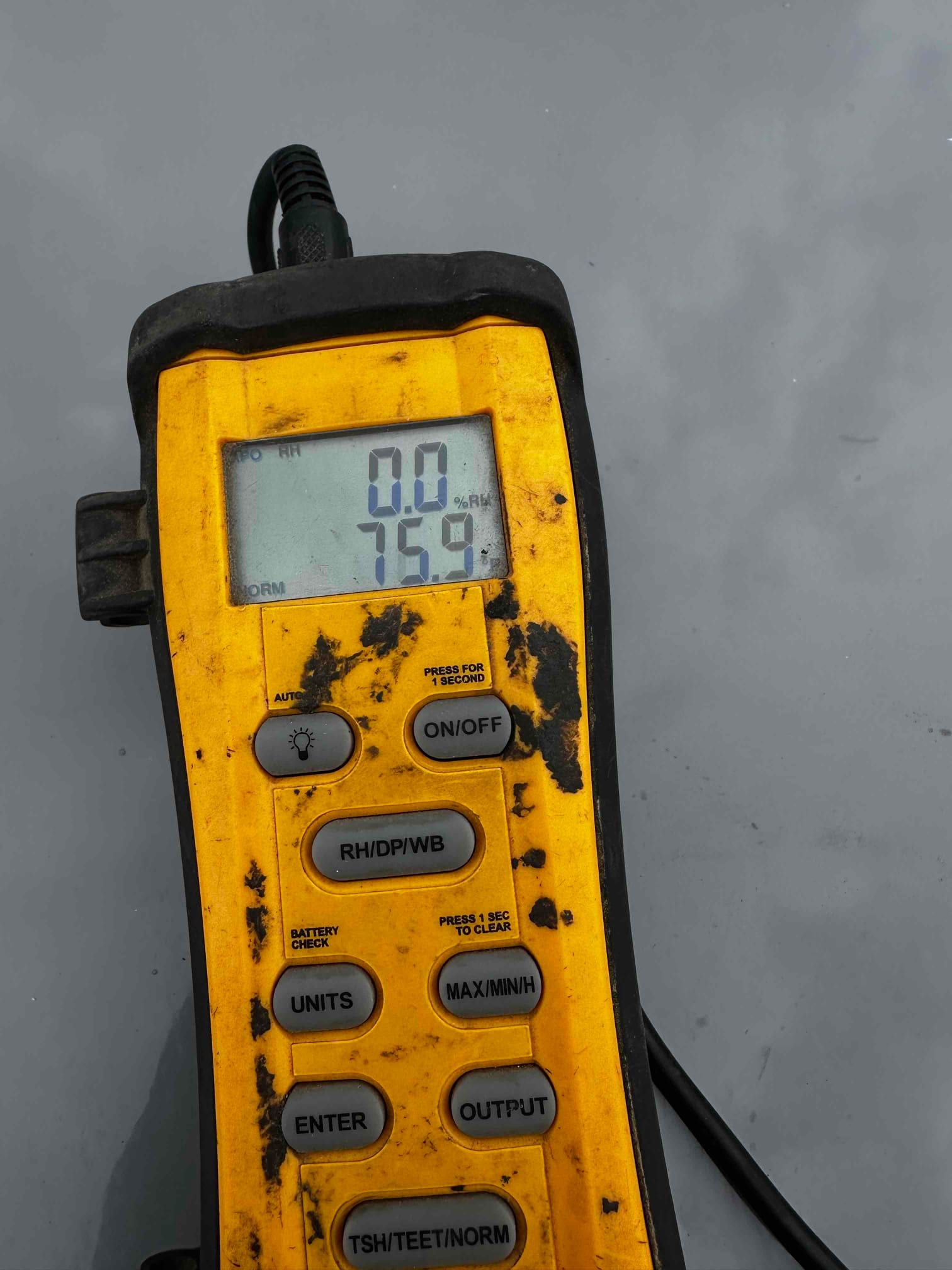 Digital thermometer shows 75.9 degrees with 0.0% RH, documenting return air temperature during commissioning.