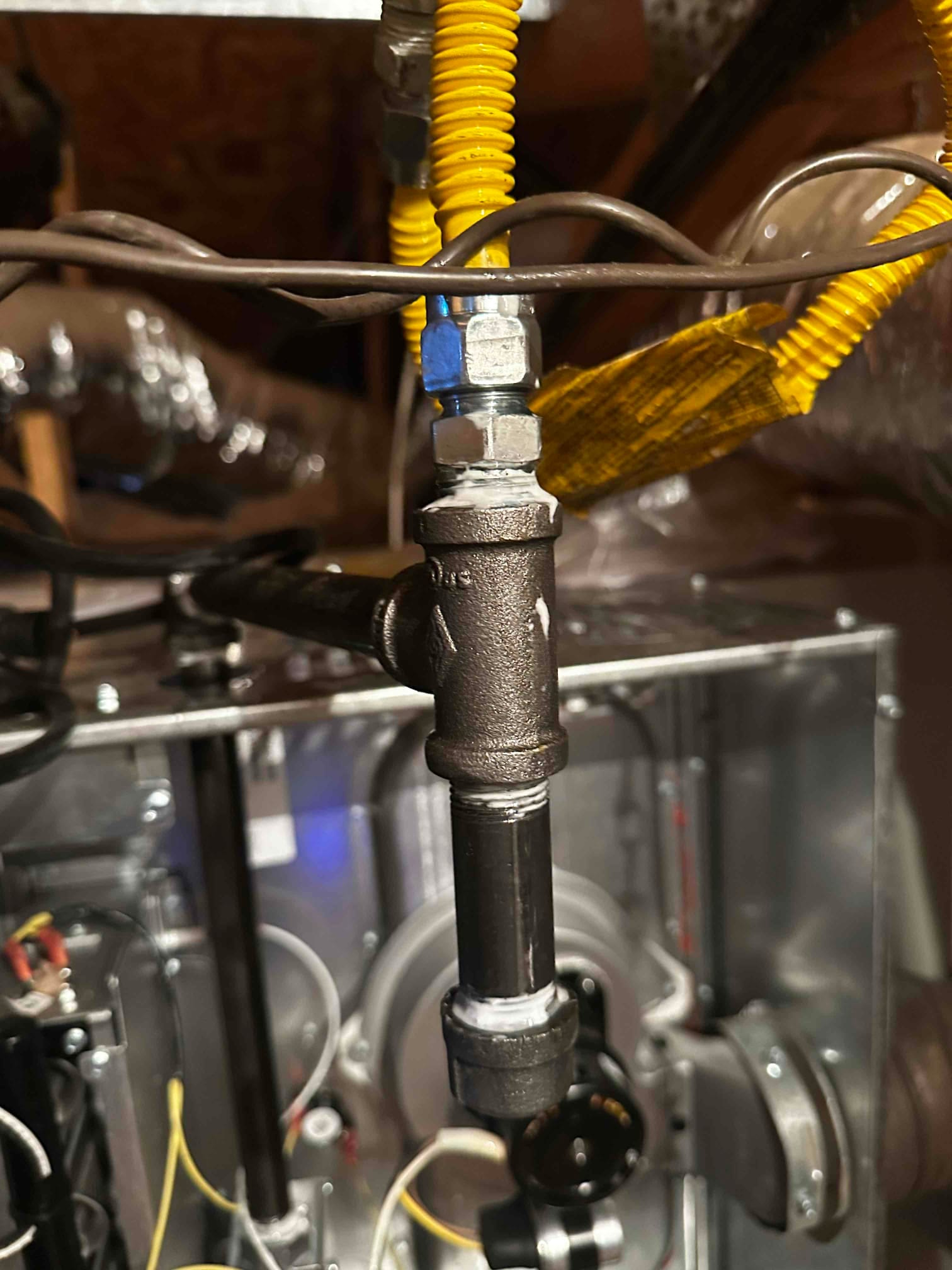 Drip leg and gas shutoff assembly connected to flexible gas line at the furnace in the attic.