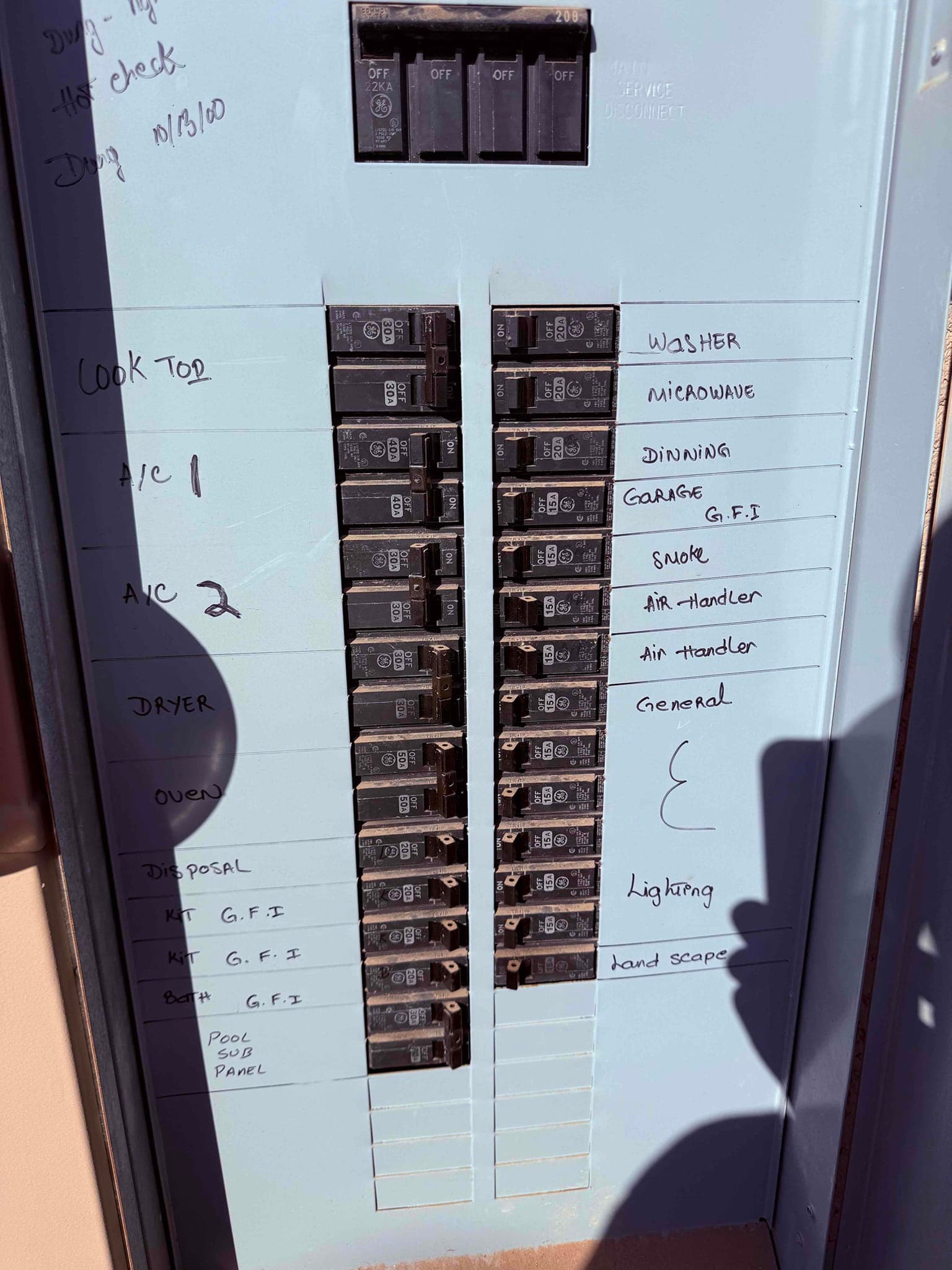 Electrical service panel with labeled breakers, including two circuits marked for A/C and one for the air handler.