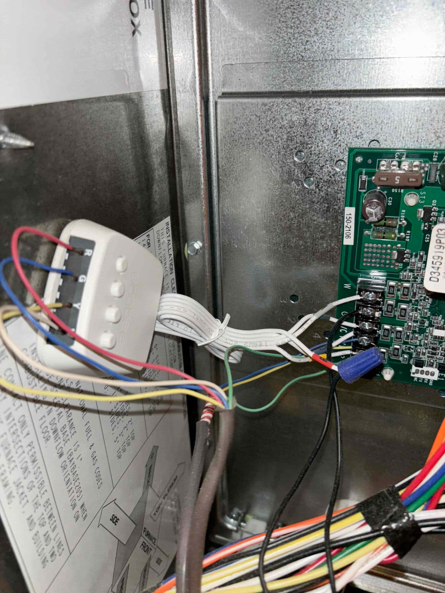Furnace control compartment showing low-voltage thermostat wiring and connections landed on the control board terminals.