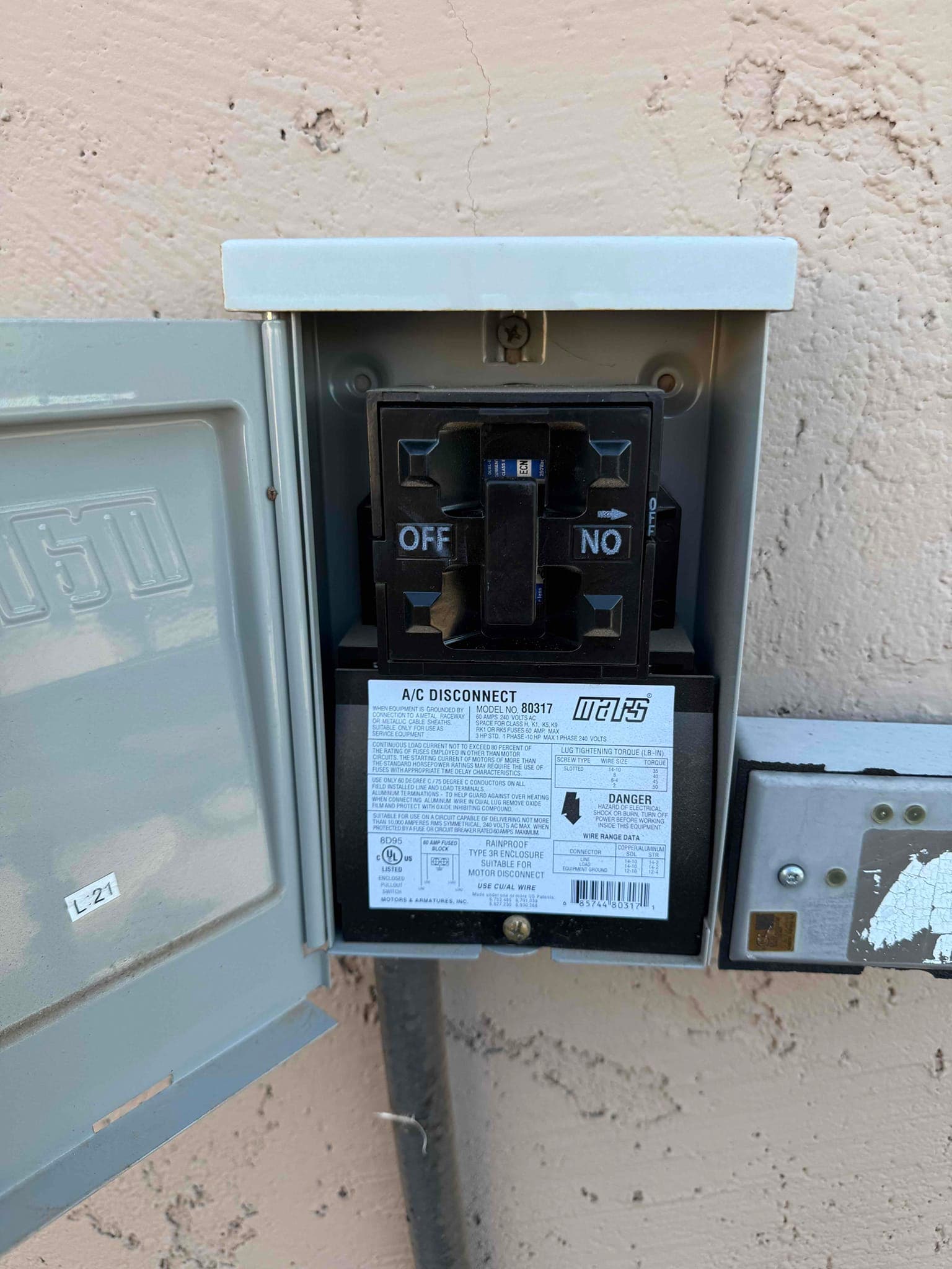 New A/C disconnect installed and open for inspection, showing ON/OFF pull handle and labeled specifications inside the rainproof enclosure.