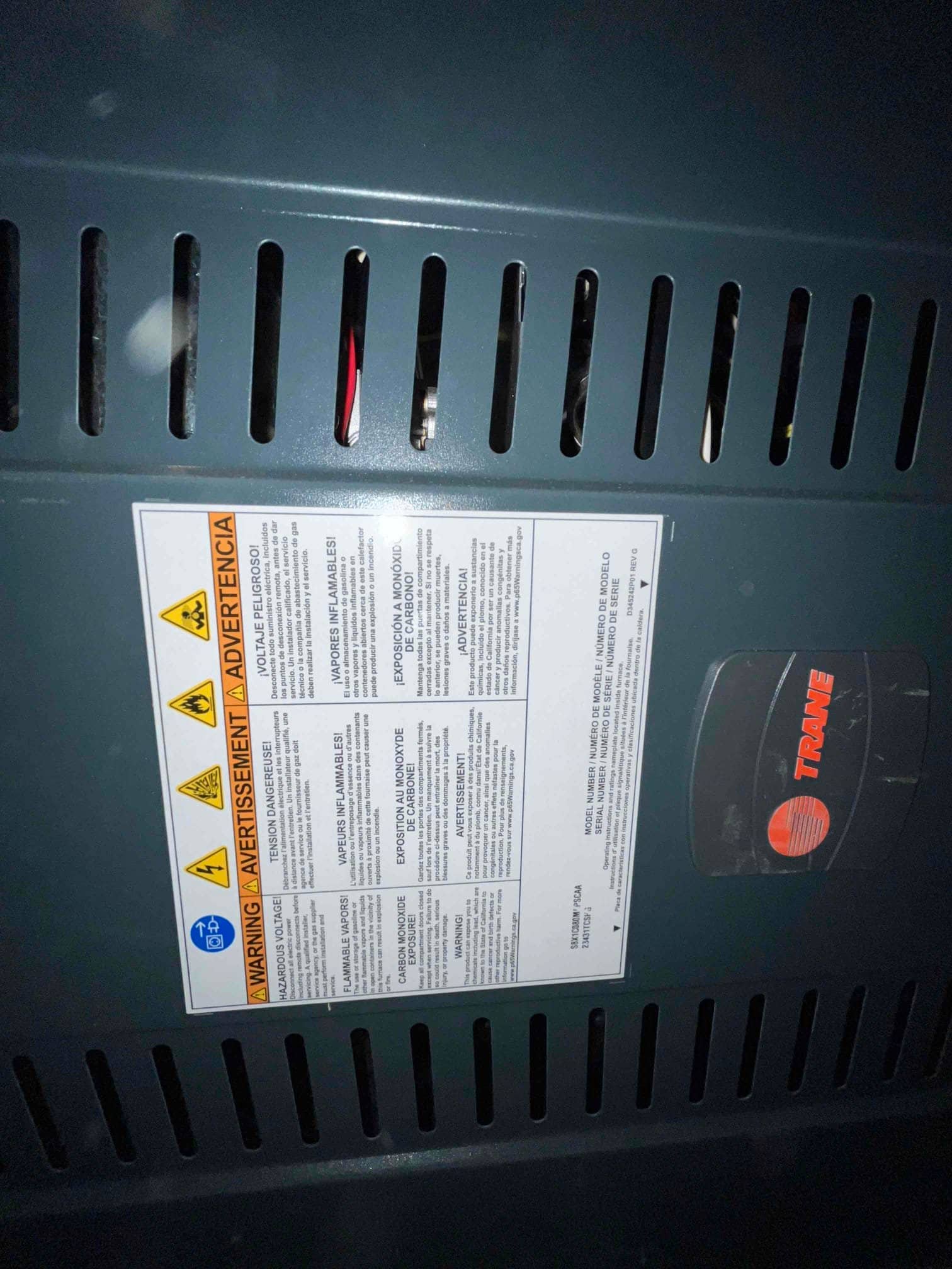 New furnace front panel with ventilation slots and safety label installed, showing clean finish and secure cabinet alignment.