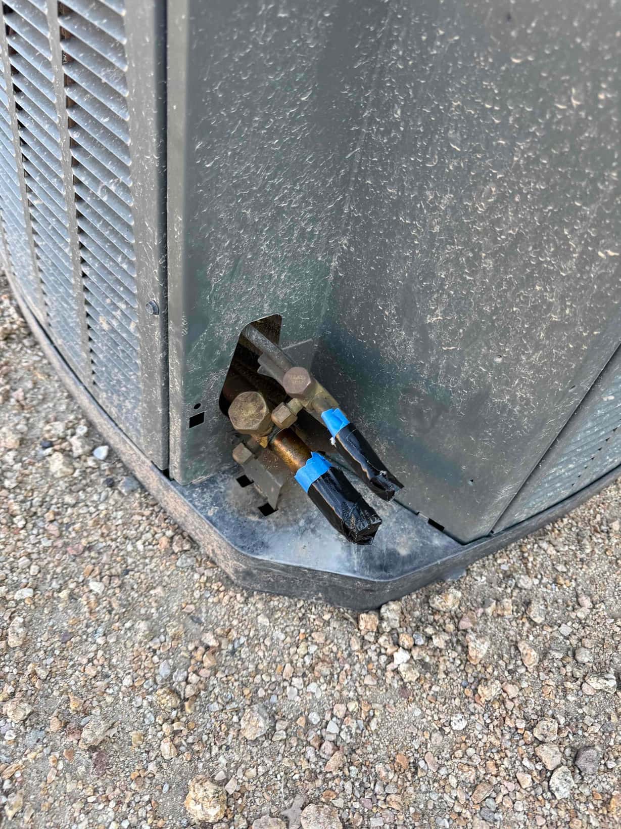 Outdoor condenser service valves with capped line set stubs taped for protection prior to connection and commissioning.