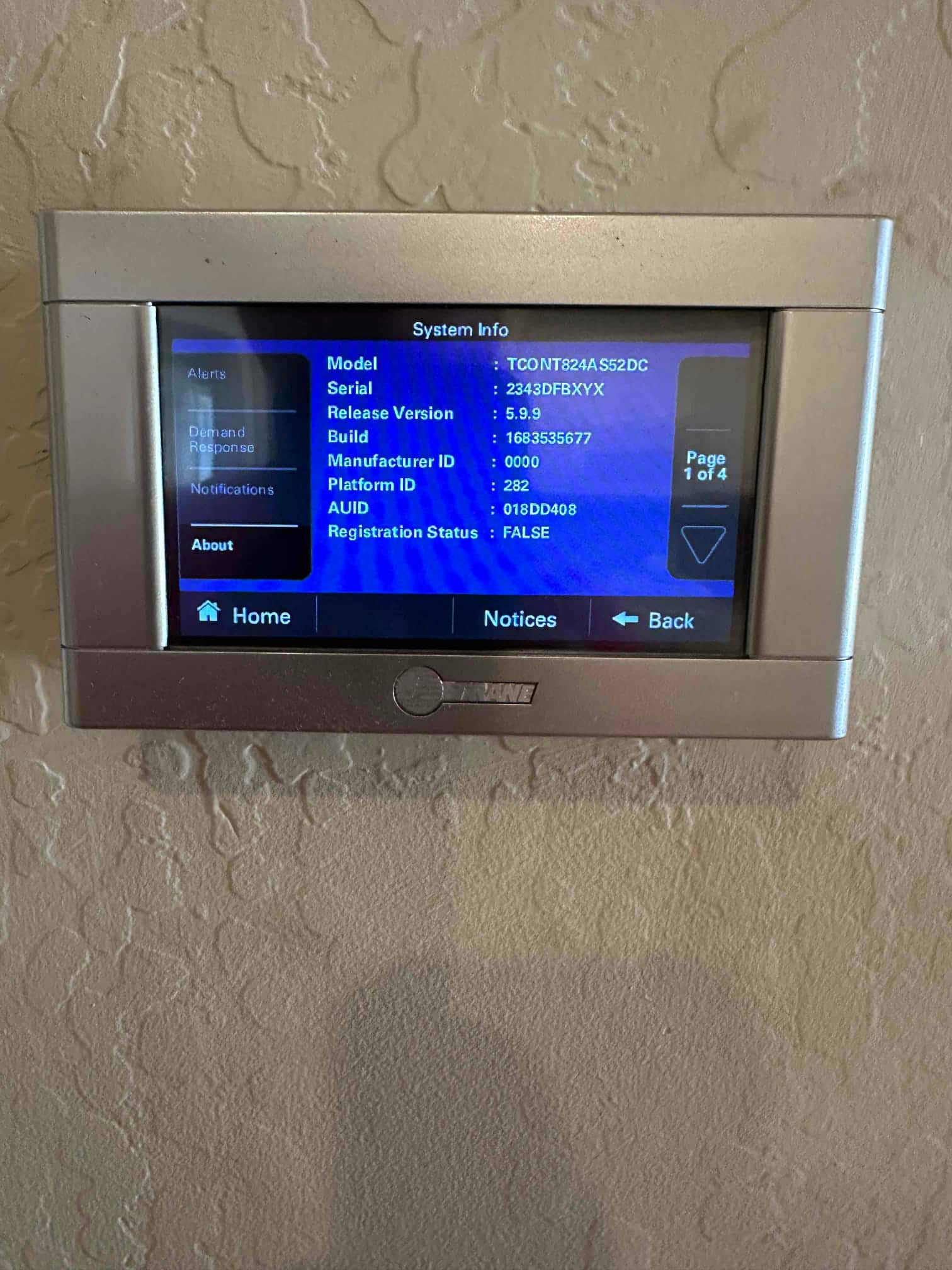 Wall-mounted thermostat displaying system information screen during setup on a newly installed HVAC system.