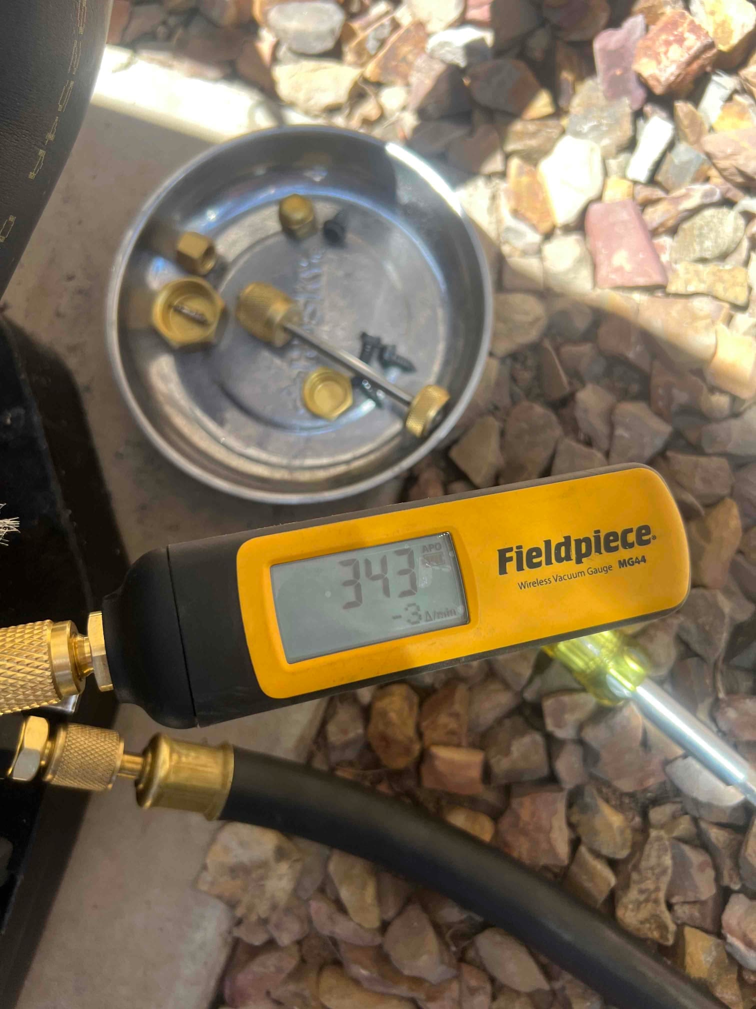 Wireless vacuum gauge connected to the system shows 343 microns during evacuation prior to refrigerant charging.