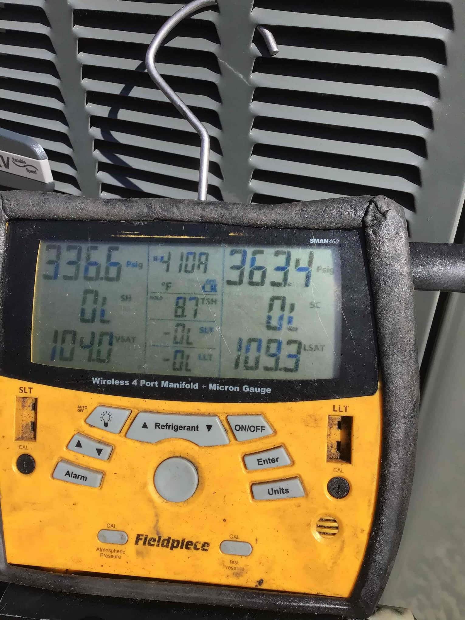Digital manifold gauges display equal high pressures on both sides during a nitrogen pressure test at the outdoor unit.