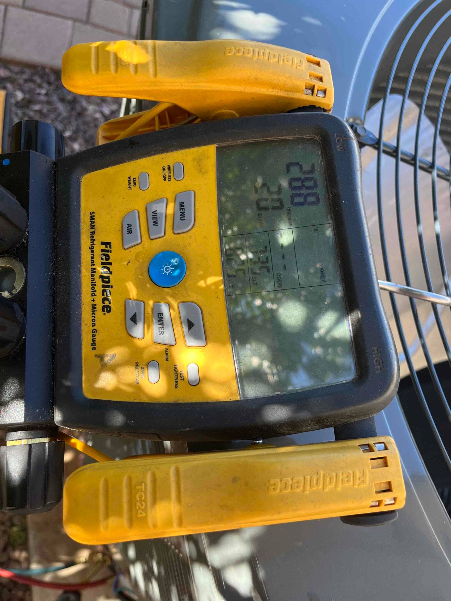 Digital micron gauge connected during evacuation shows a deep vacuum achieved on the new system before refrigerant charging.
