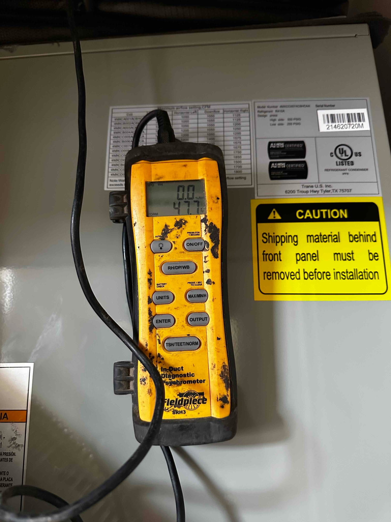 Digital thermometer on the air handler displays 47.7 degrees Fahrenheit during supply air temperature check.