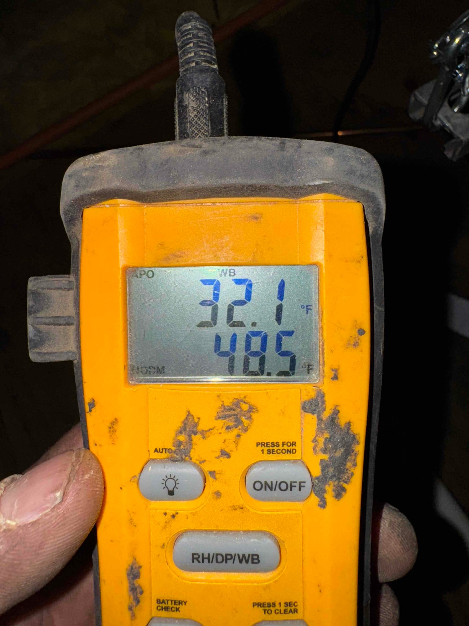 Handheld digital thermometer displays 32.1°F and 48.5°F readings during HVAC air-side commissioning.