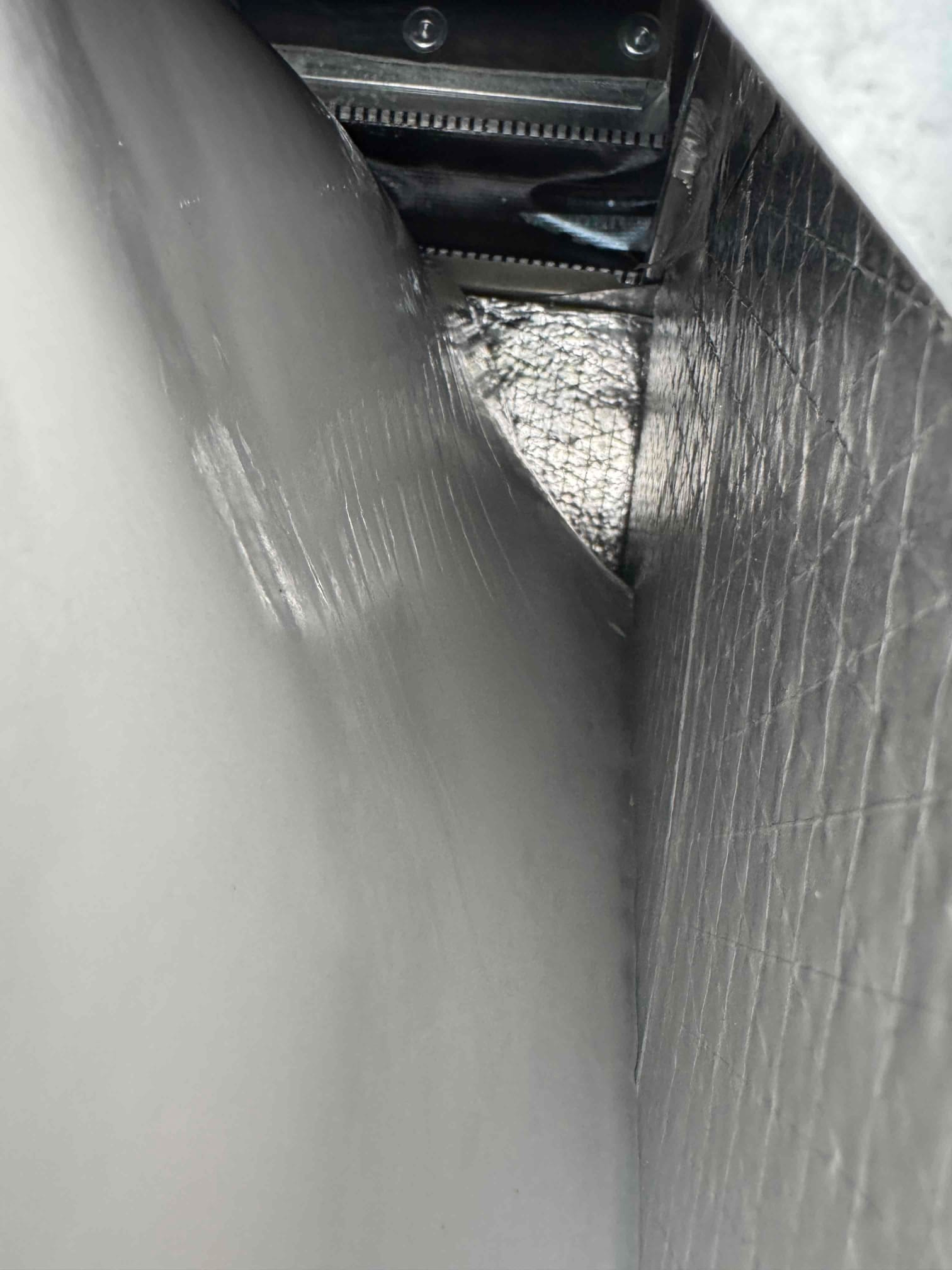 Interior of an air handler plenum showing clean insulated duct lining and sealed joints after blower cleaning.