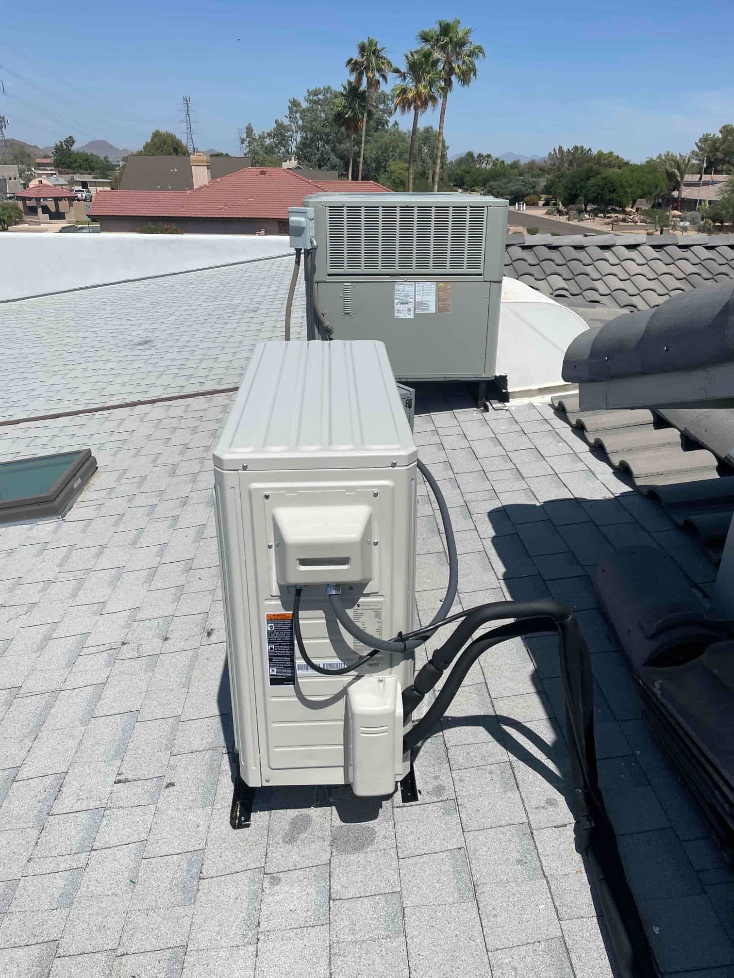 Mini-split outdoor unit mounted on roof with insulated line set and electrical whip routed to the condenser.