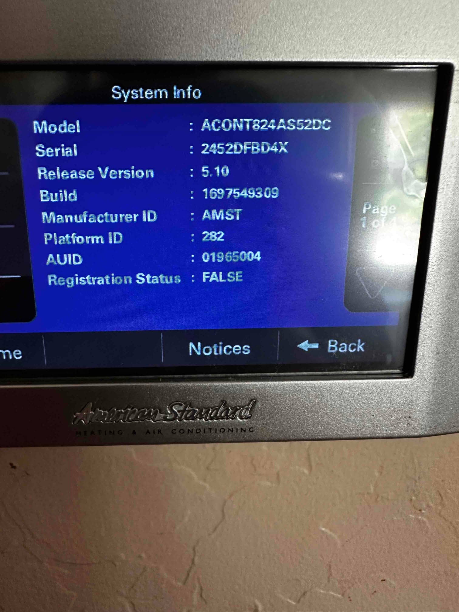 Thermostat system information screen displays model, serial, firmware version, and registration status after installation setup.