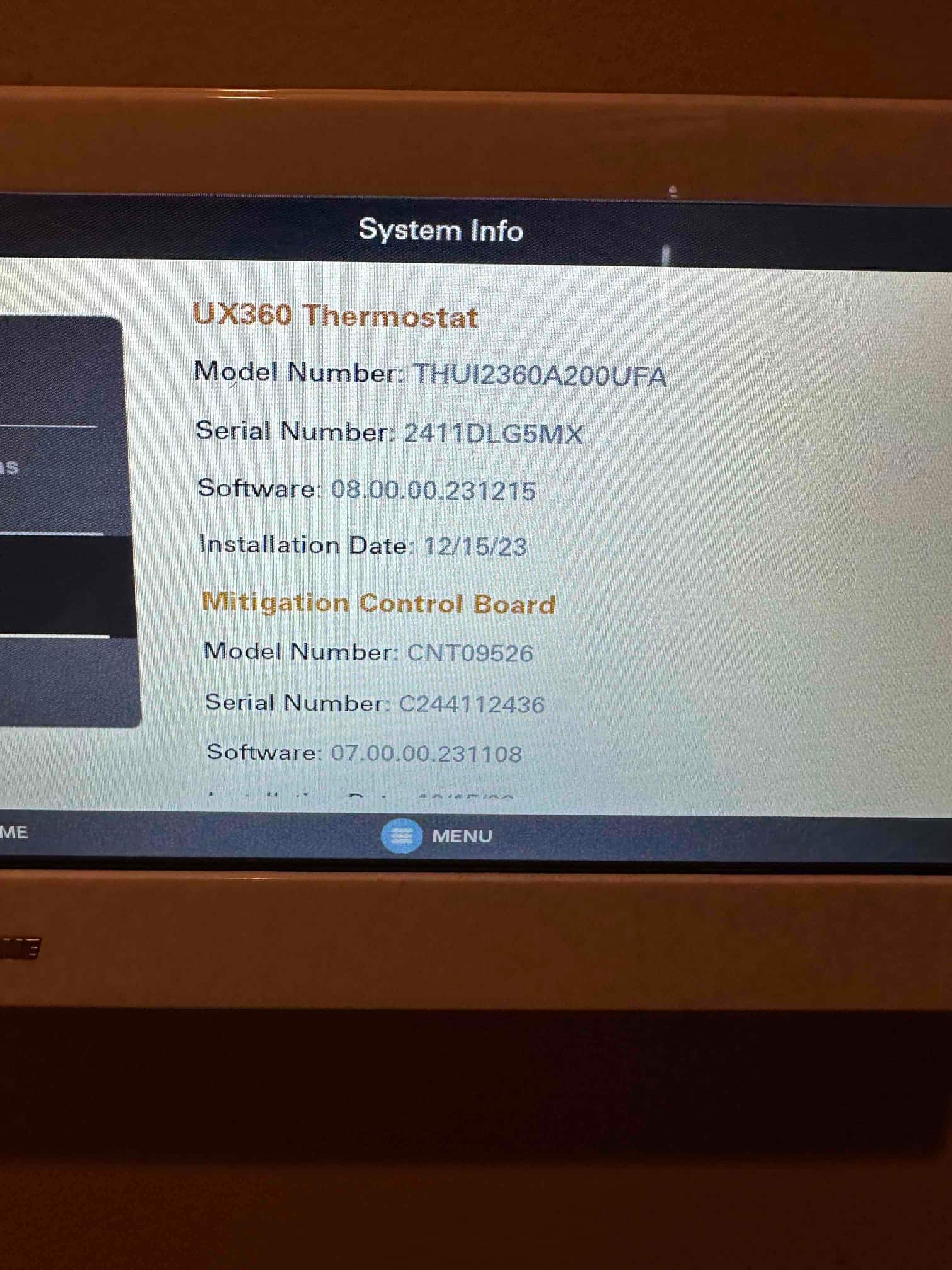 Thermostat touchscreen displays system information and software versions during setup on a newly installed control.