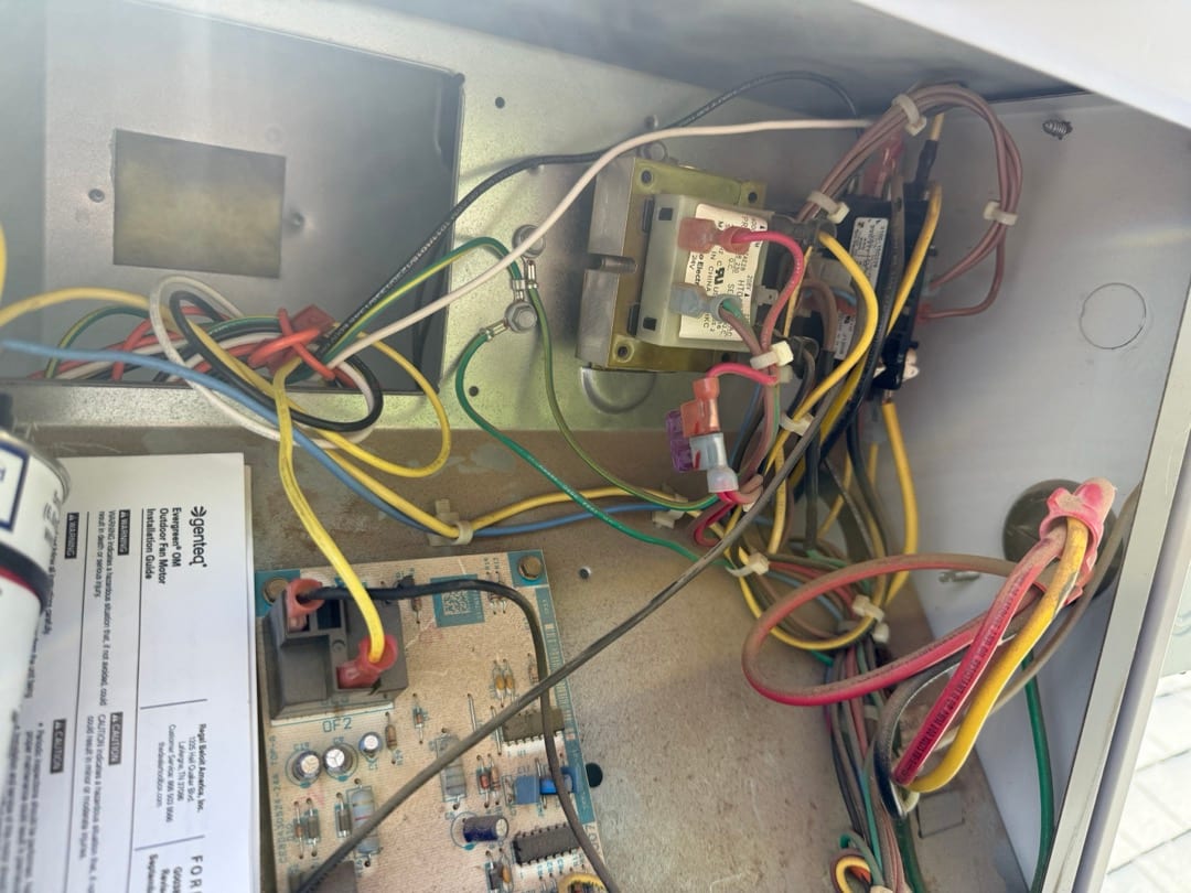 Condenser control compartment showing contactor, control transformer, circuit board, and multiple connected low-voltage and line-voltage wires.
