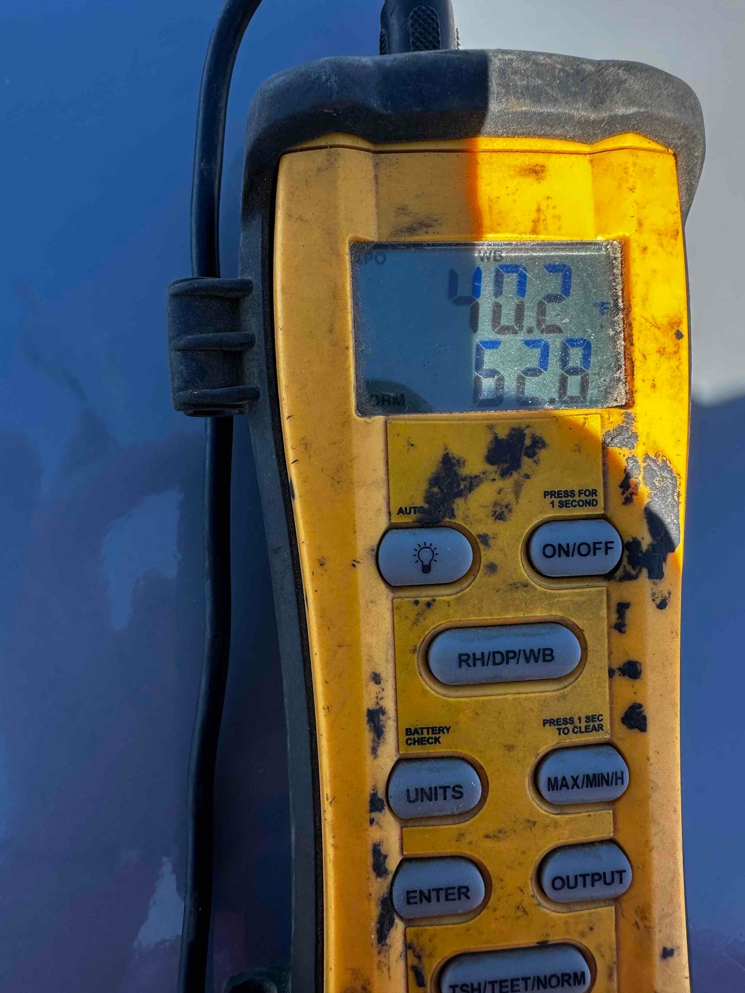 Digital thermometer displays 40.2 and 62.8 degrees during air temperature checks on the HVAC system.